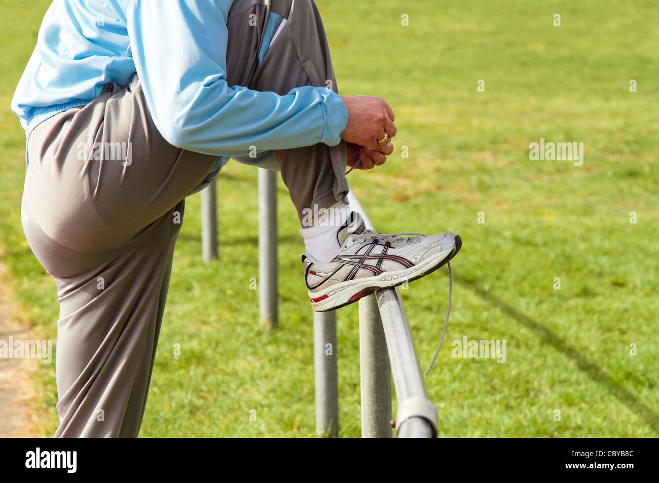 Sportsman attaching his registration tag to his running shoe before a