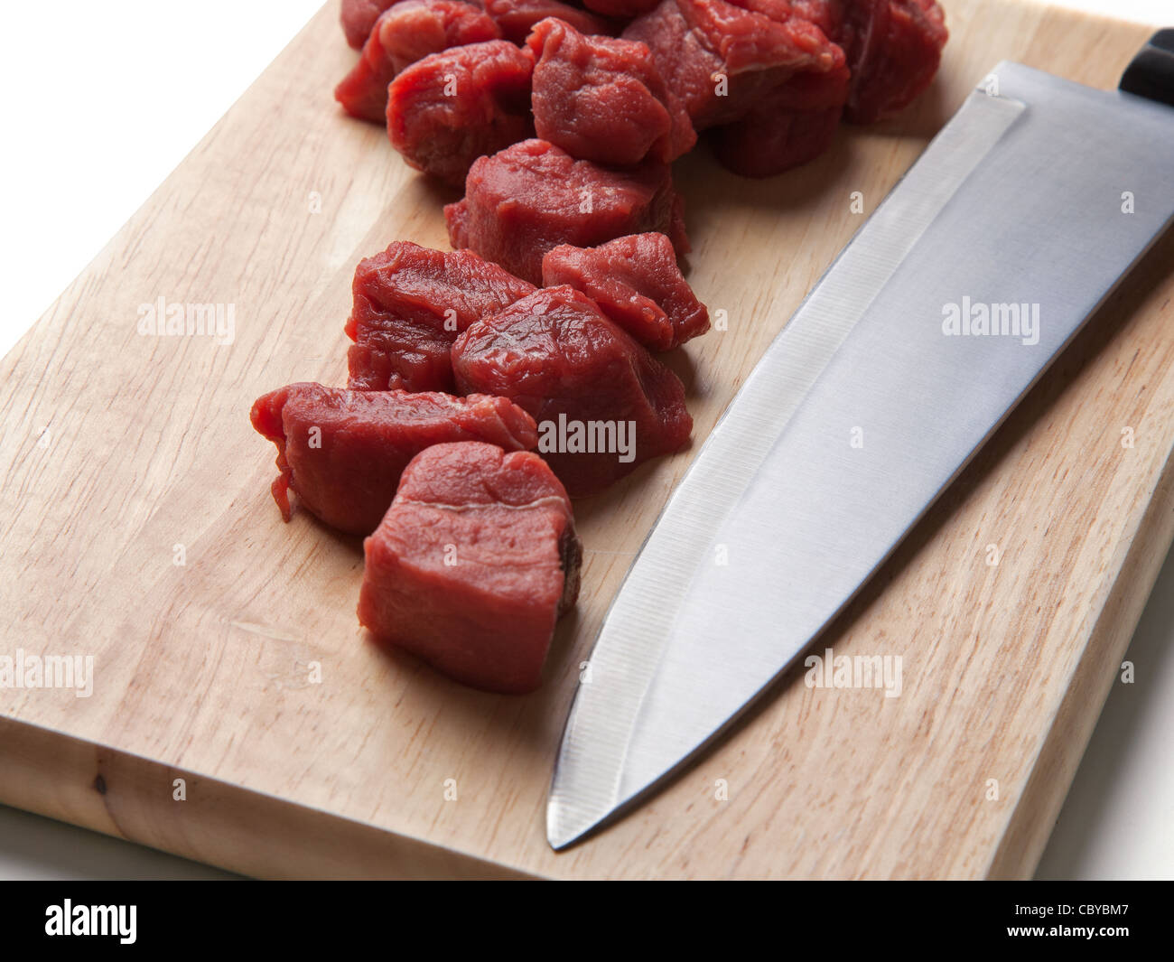 Diced chuck steak on chopping board with knife Stock Photo