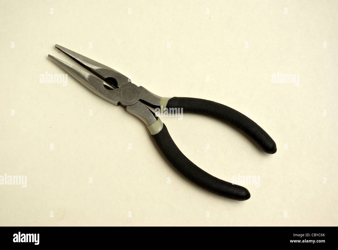 A pair of needle nose pliers sits on a white background Stock Photo