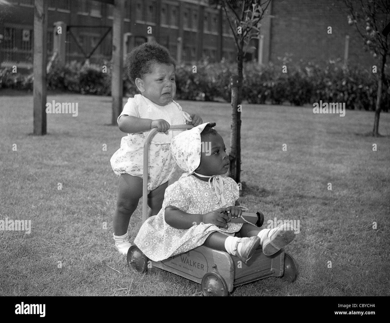 Toddlers with baby walker in the West Midland England Uk 1957 Stock Photo