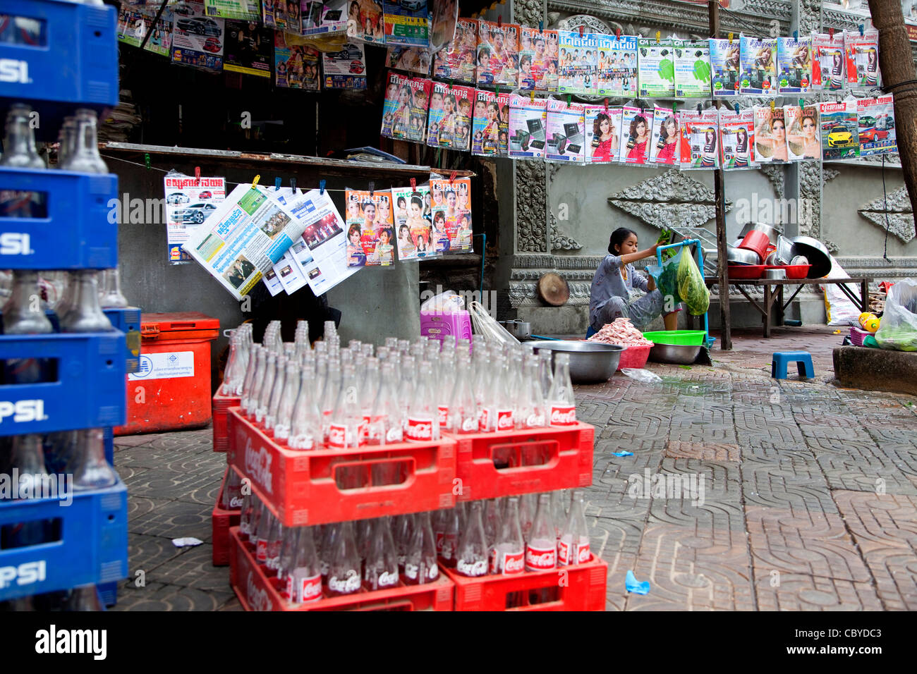 Kiosk selling newspapers and magazines and traditional restaurant on the street with Coke and Pepsi, Phnom Penh, Cambodia, Asia Stock Photo