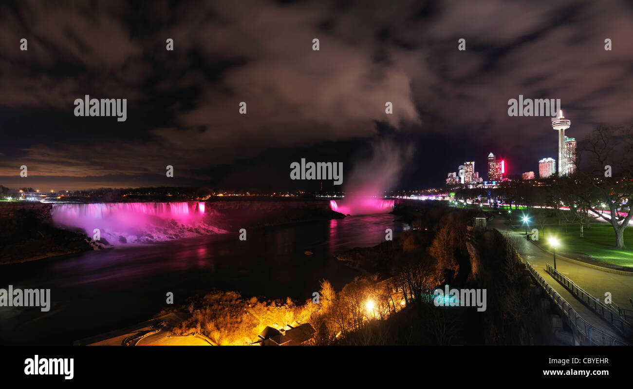 Nighttime panoramic scenery of Niagara Falls illuminated with colorful lights. Ontario, Canada. Stock Photo
