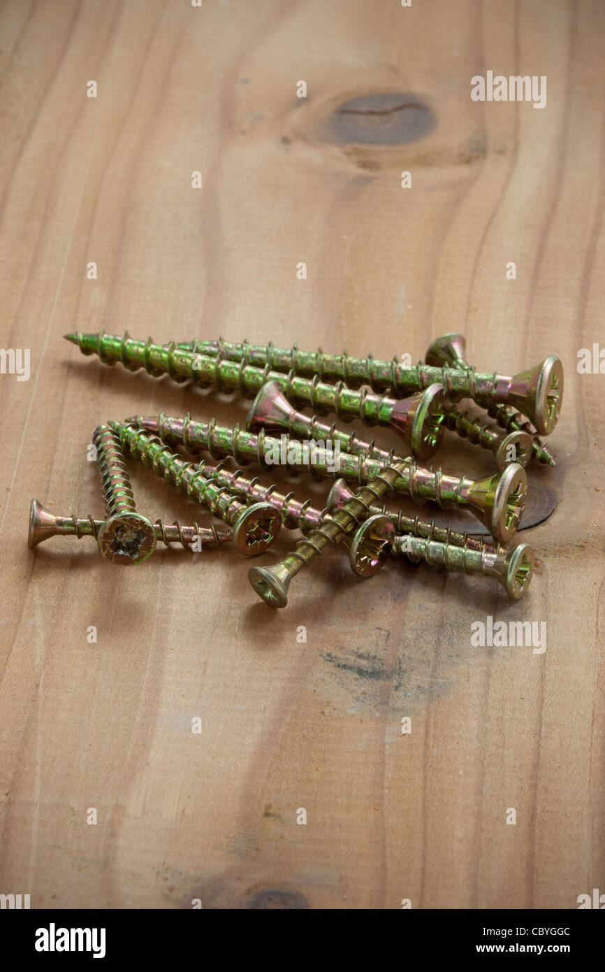 A pile of brass screws on a floorboard Stock Photo Alamy