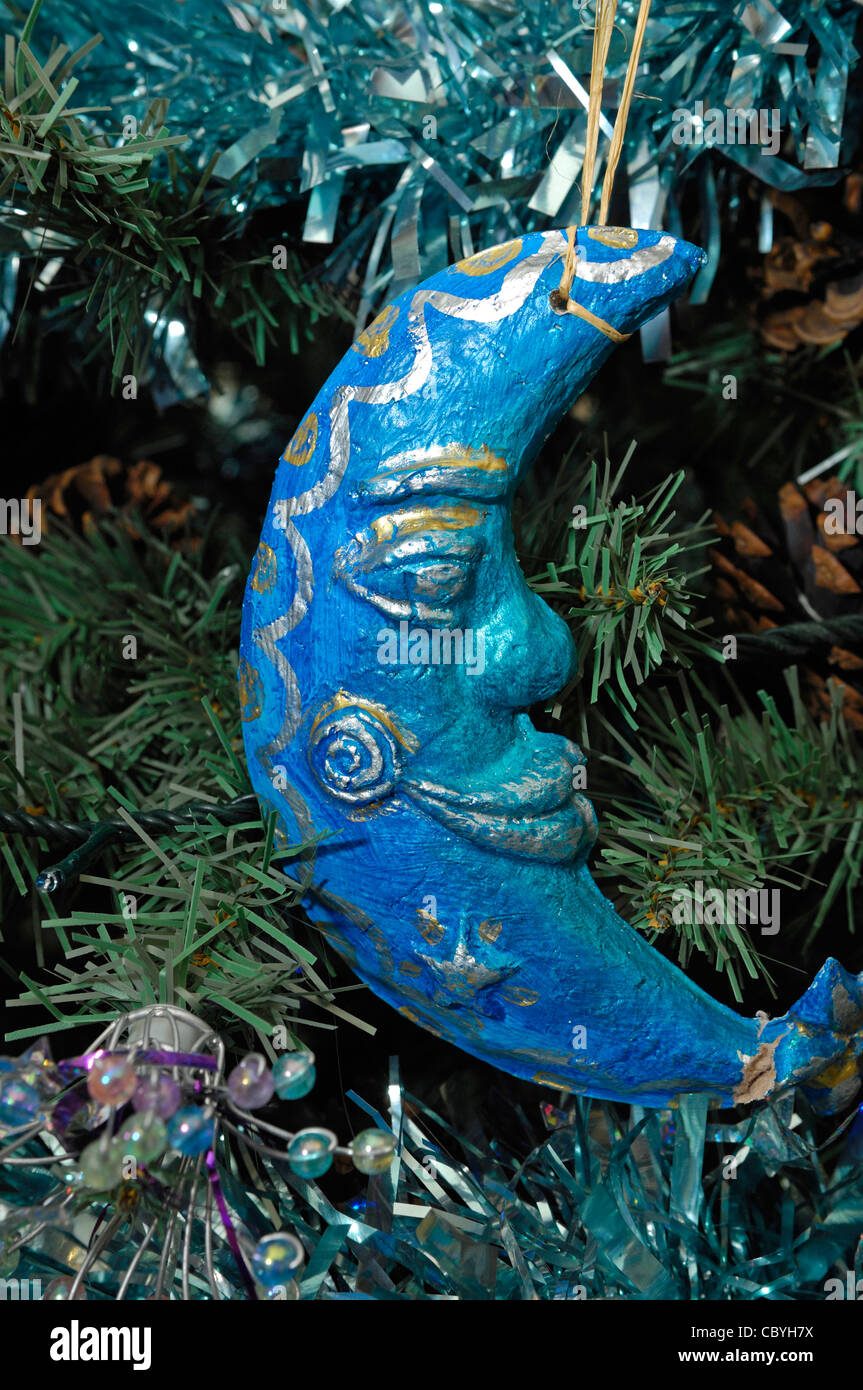 Christmas decoration in the shape of a persons face and half moon painted blue with gold banding. Stock Photo