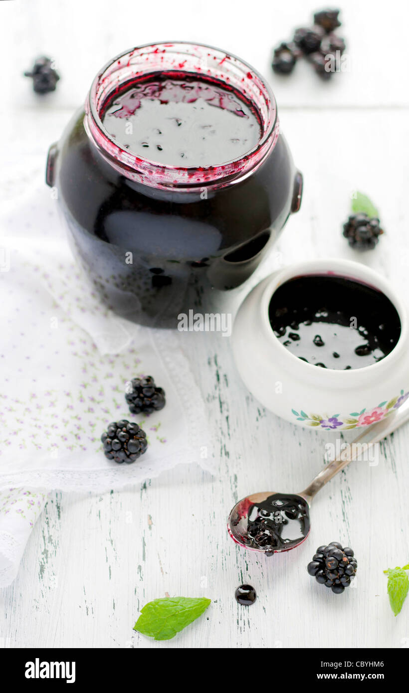 A closeup of blackberry jam on a white wooden table Stock Photo