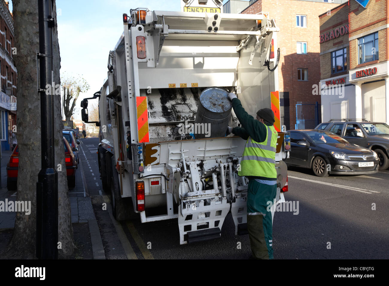 veolia worker working on behalf of local brent council collecting refuse waste in a bin lorry london uk united kingdom Stock Photo
