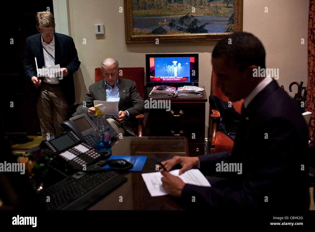 President Barack Obama edits his statement before officially announcing that a US special forces team killed terrorist Osama bin Laden May 1, 2011 at the White House in Washington, DC. A television news report announces that bid Laden had been killed and a photograph of him appeared on the televisio Stock Photo