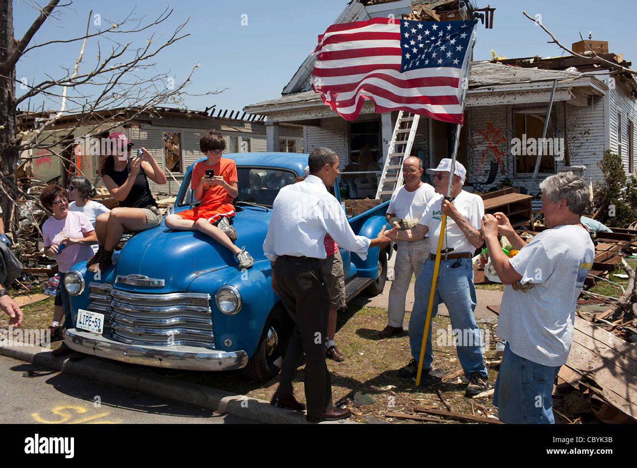 President Barack Obama shakes hands with Hugh Hills, 85, in front of his home destroyed by a tornado May 29, 2011 in Joplin, MO. Hills told the President he hid in a closet during the tornado, which destroyed the second floor and half the first floor of his house Stock Photo