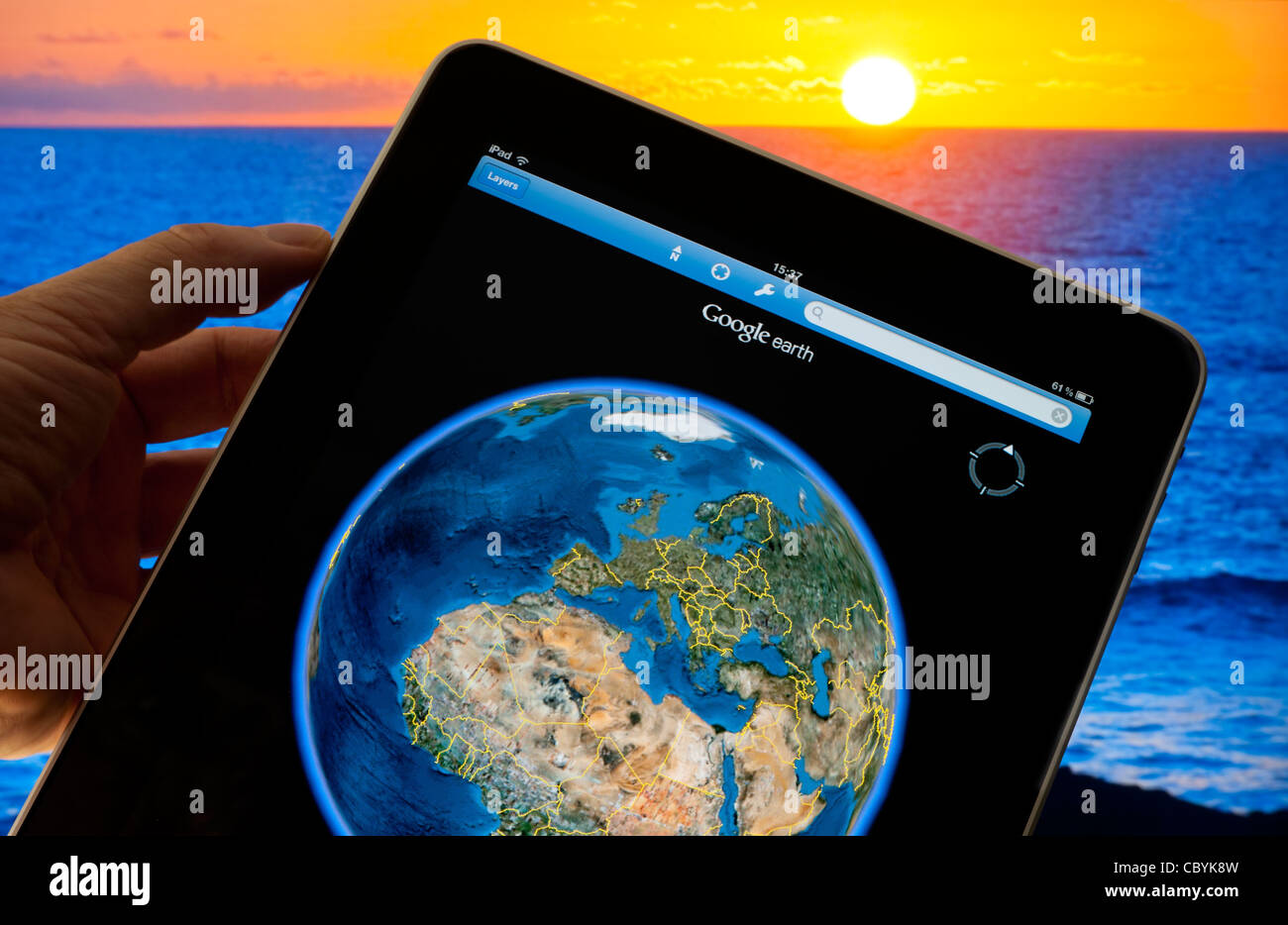 Apple iPad smart tablet with Google Earth streaming application 4g on screen featuring world globe, with UK France Africa etc, sunset in background Stock Photo