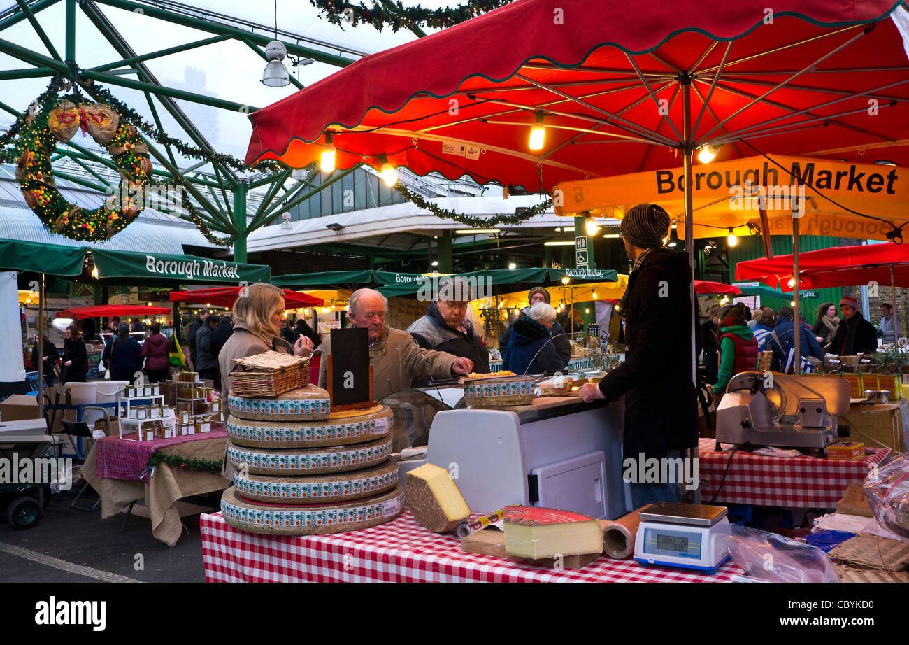 Cheese market stall tastings at Borough Market with Christmas decorations Southwark London Stock Photo