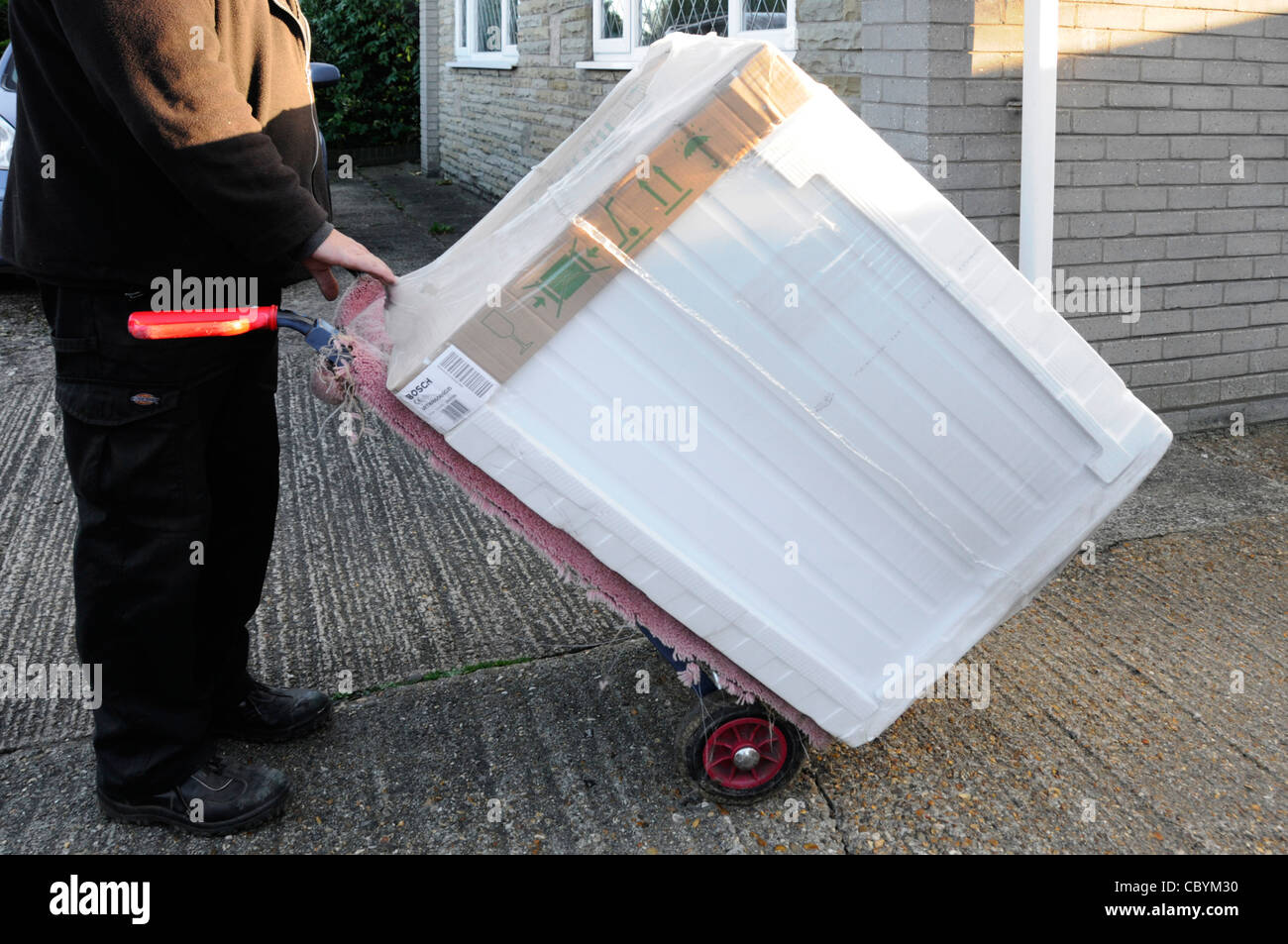 New tumble dryer being delivered by white electrical goods supplier to domestic household Essex England UK Stock Photo