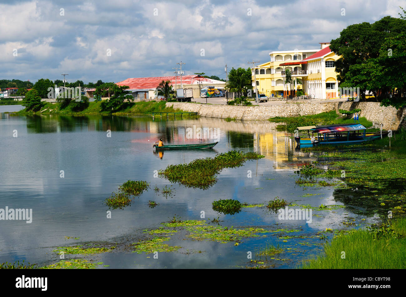 FLORES, Guatemala - Part of the waterfront of Flores in Lake Peten Itza, with small traditional boats moored against the shallows against the shoreline. Stock Photo