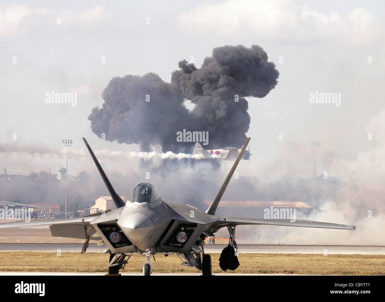 The Pearl Harbor reenactment of 'Tora! Tora! Tora!' fills the sky with smoke as a Japanese Zero streaks by behind an F-22 Raptor during AirFest 2008 at Lackland Air Force Base, Texas. Stock Photo