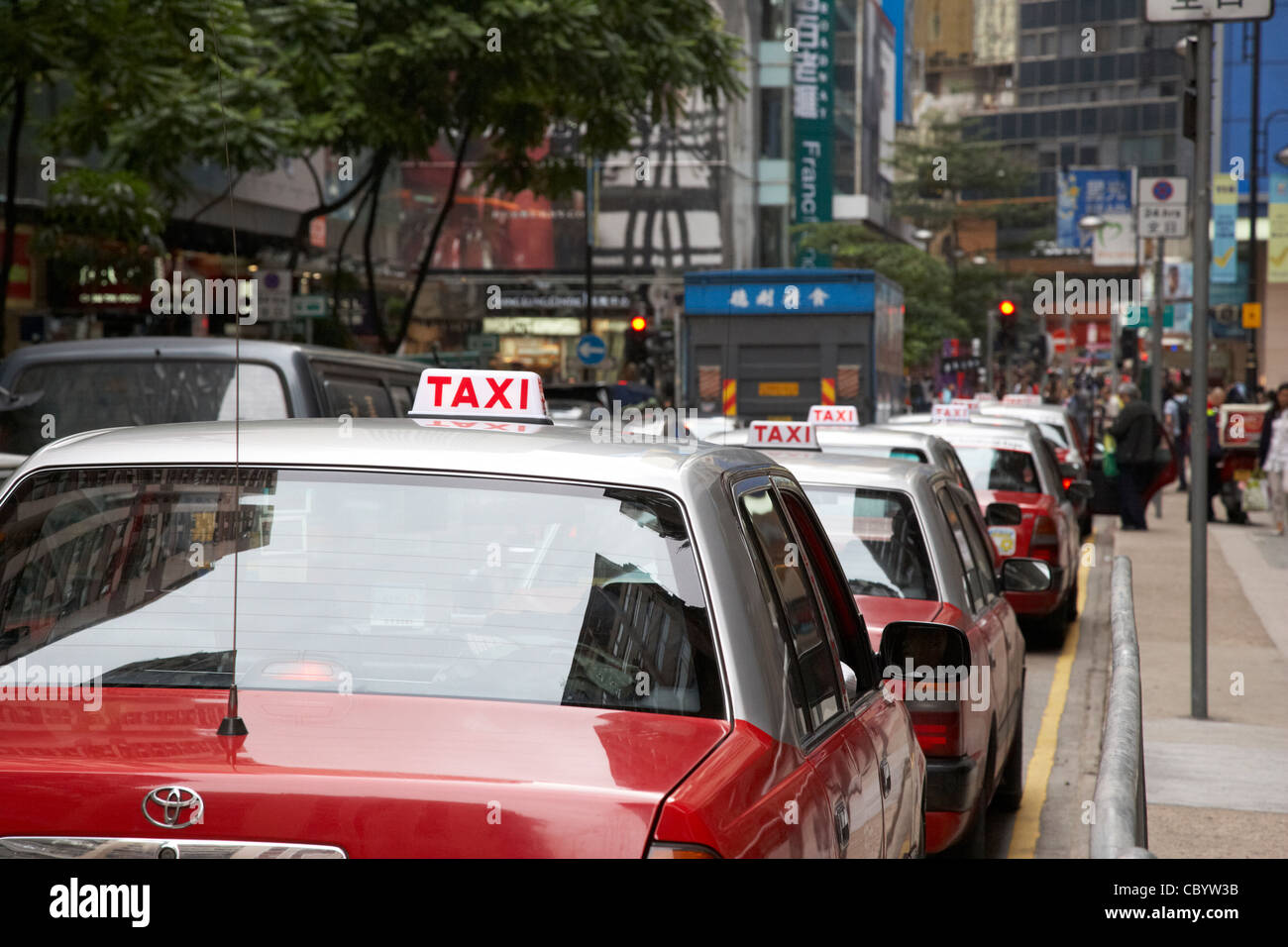 row of red and silver public taxis on a shopping street in hong kong hksar china asia Stock Photo