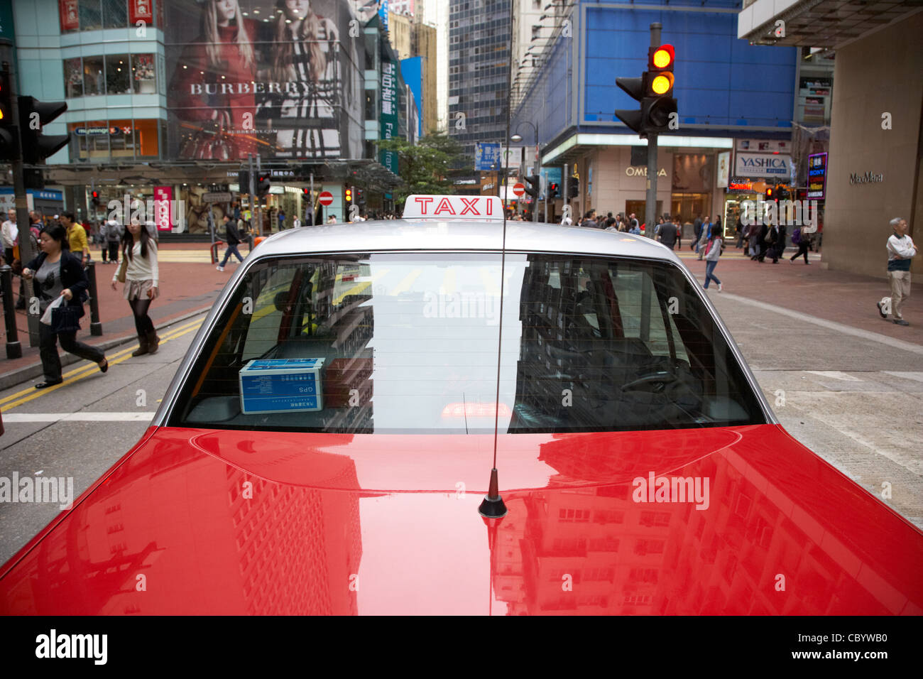 red and silver public taxi at traffic lights on a shopping street in hong kong hksar china asia Stock Photo