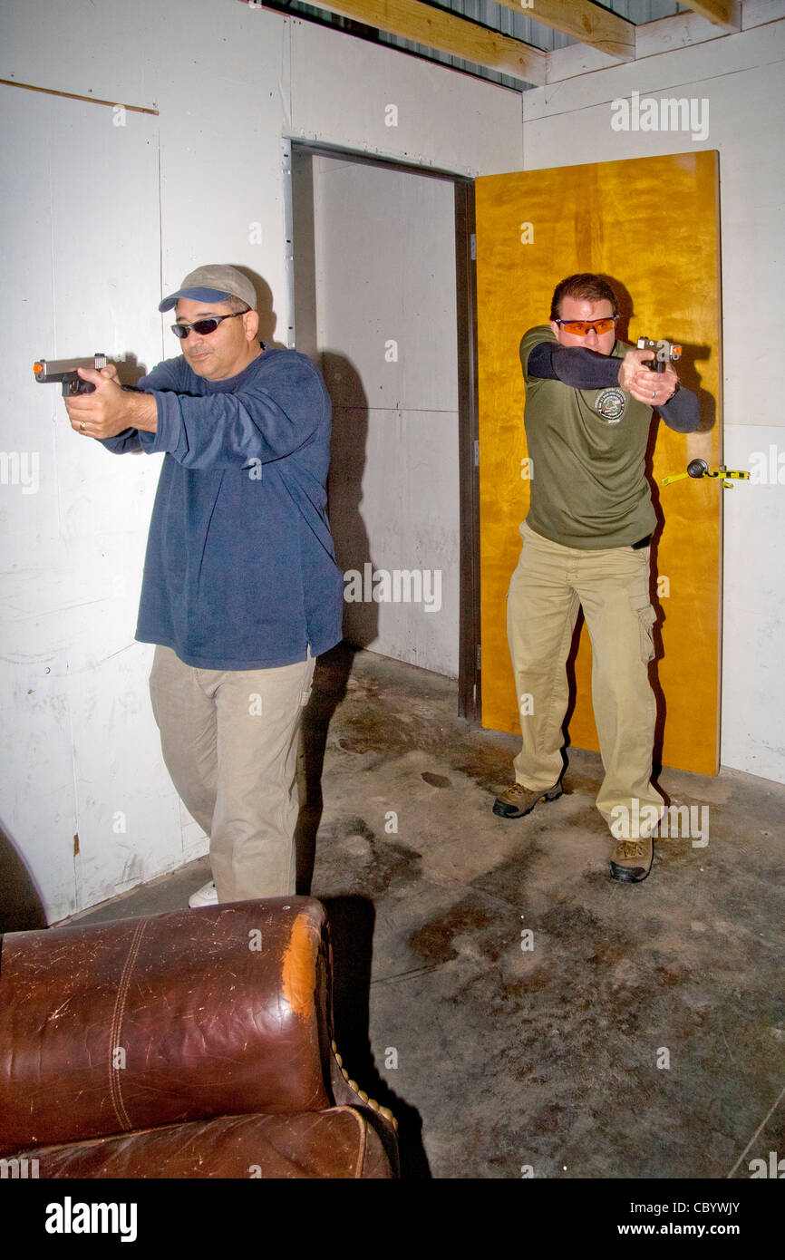 Under the eye of an instructor, law enforcement agents practice entering or 'breaching' a room with weapons. Stock Photo