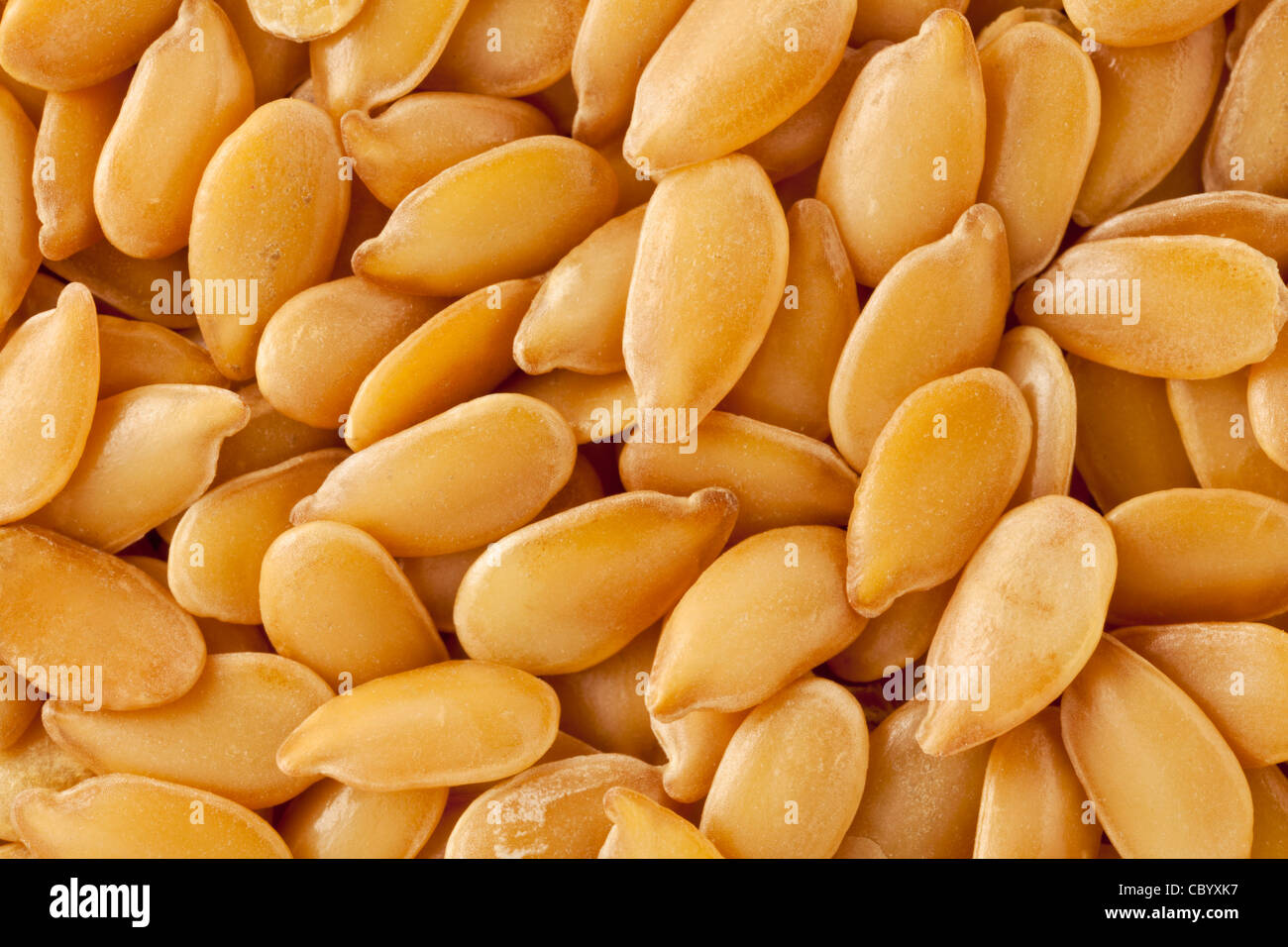 background of golden flax seeds, two times life-size magnification Stock Photo