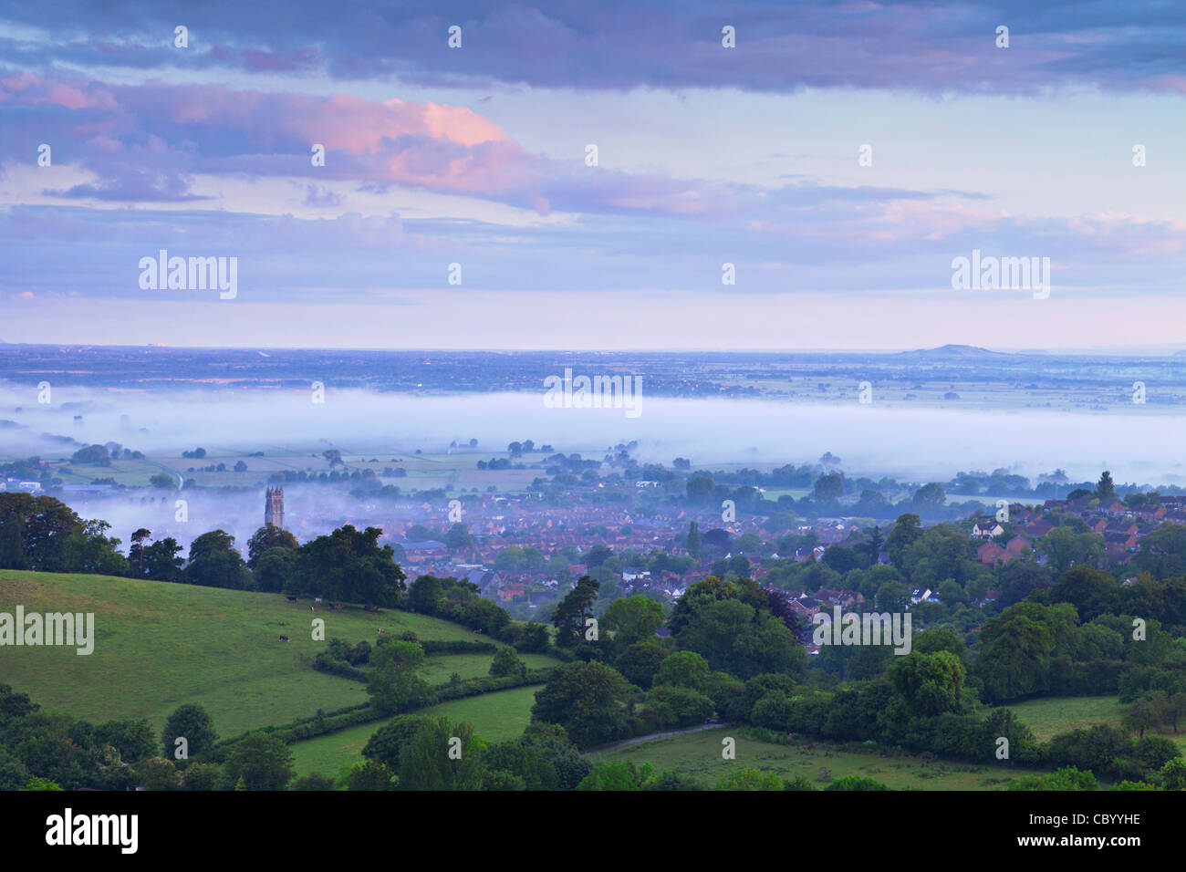 The town of Glastonbury and the Somerset Levels, shrouded in mist, from Glastonbury Tor, in pre-dawn light. Stock Photo