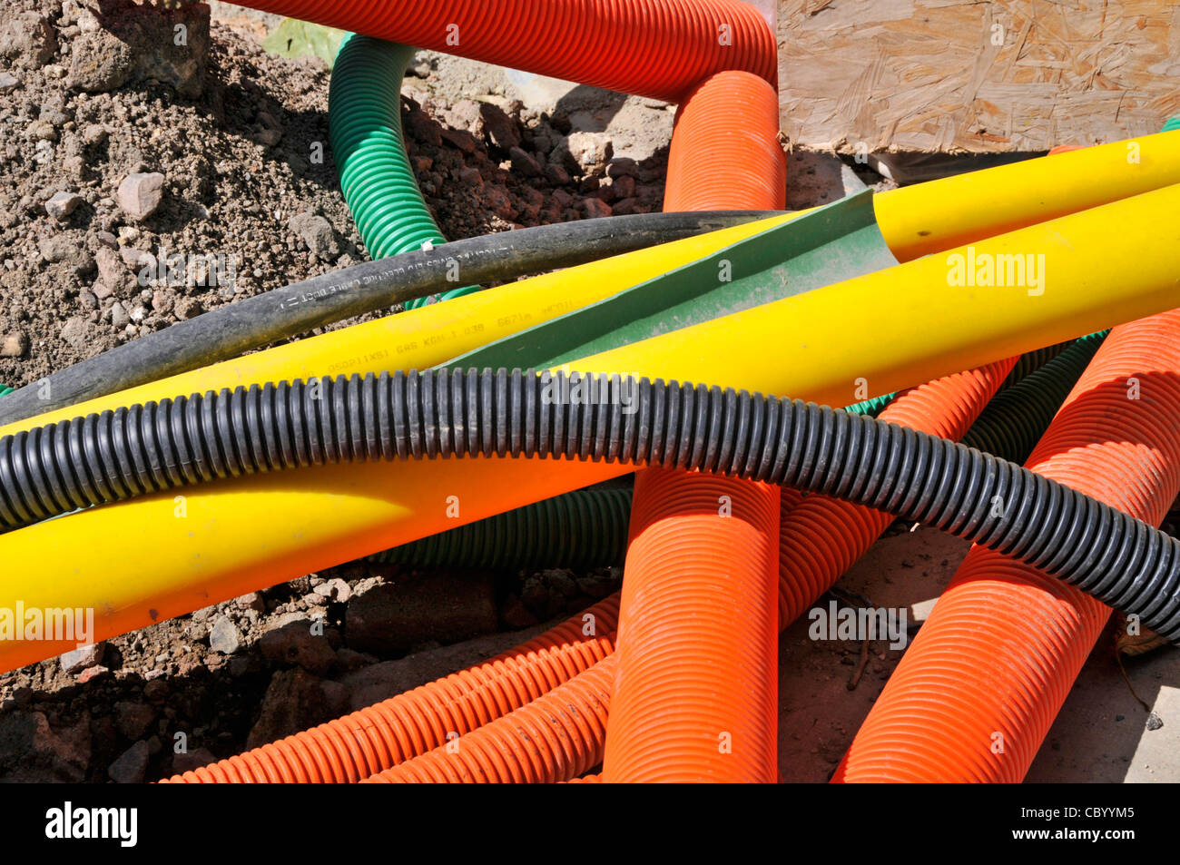 Street scene road works jumbled heap of assorted colourful plastic tubing offcuts for underground utility services gas electricity London England UK Stock Photo