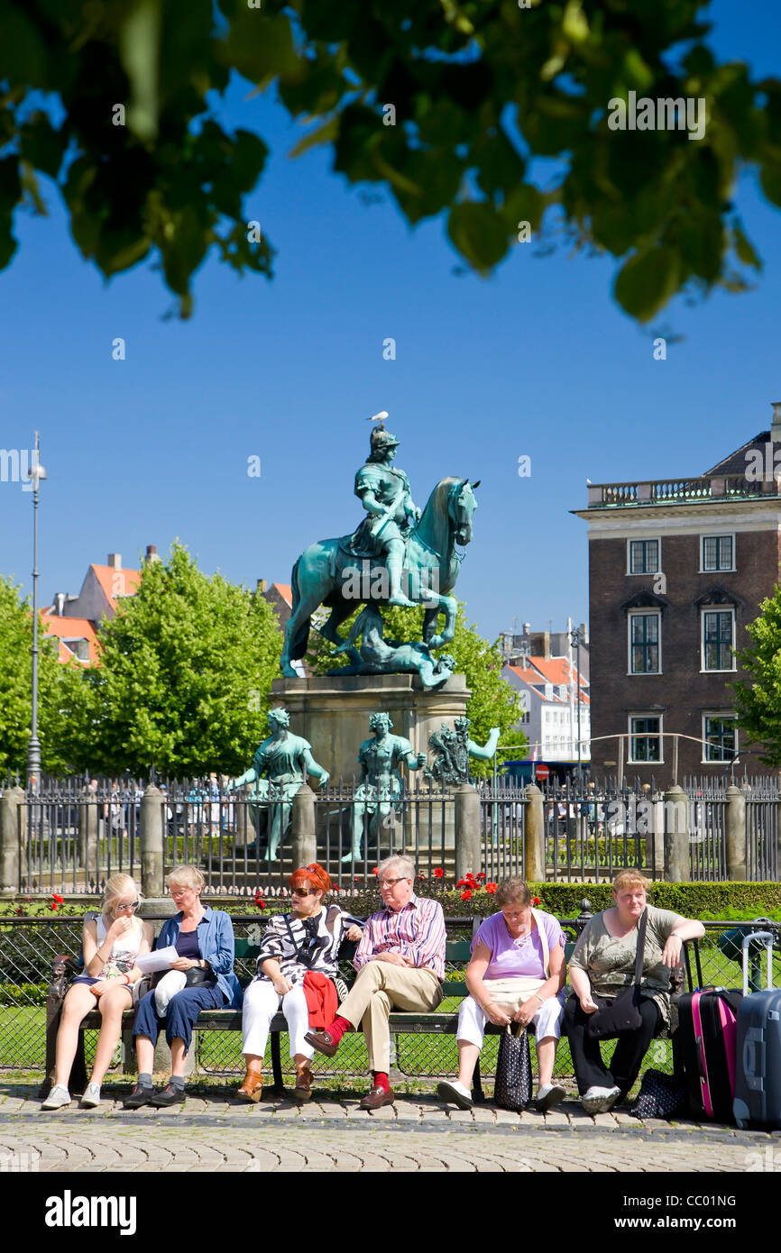 Group of people resting on a bench at the Kings New Square in Copenhagen Stock Photo