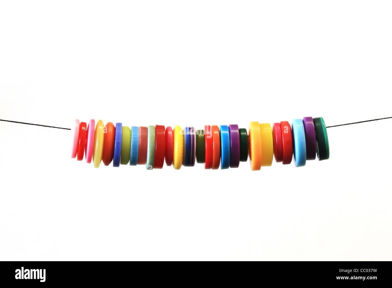 Colourful buttons on thread with a white background Stock Photo