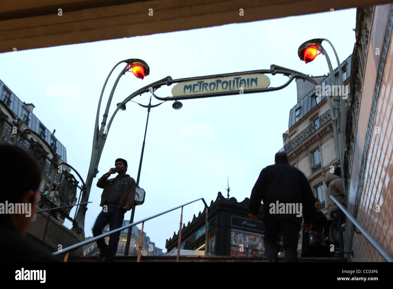 People enter and exit the Paris Metro subway on a winter day at dusk Stock Photo