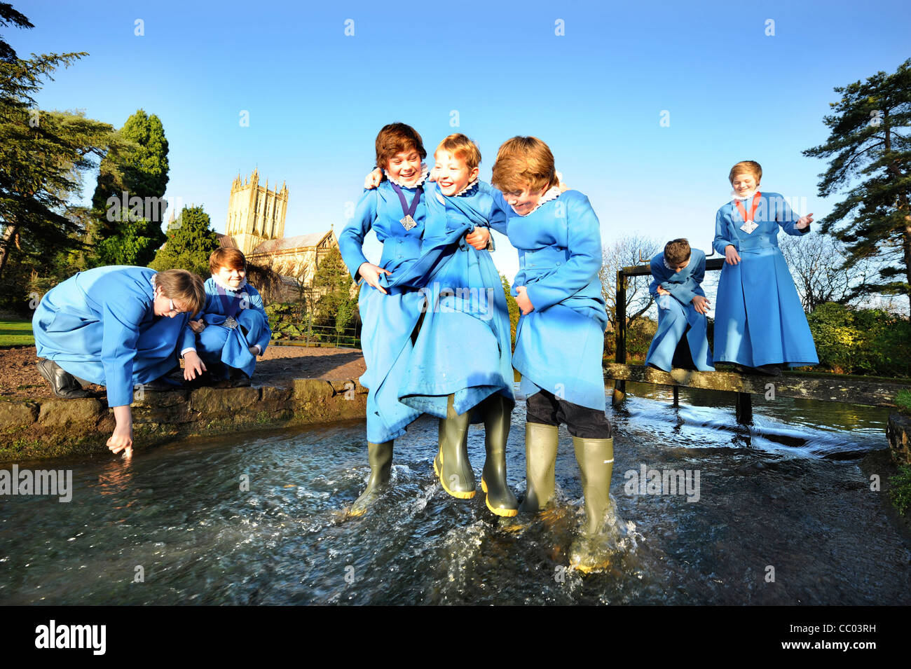 Boy choristers from the Wells Cathedral Choir in Somerset UK take a break from rehearsals playing by 'The Wells' pond after whic Stock Photo