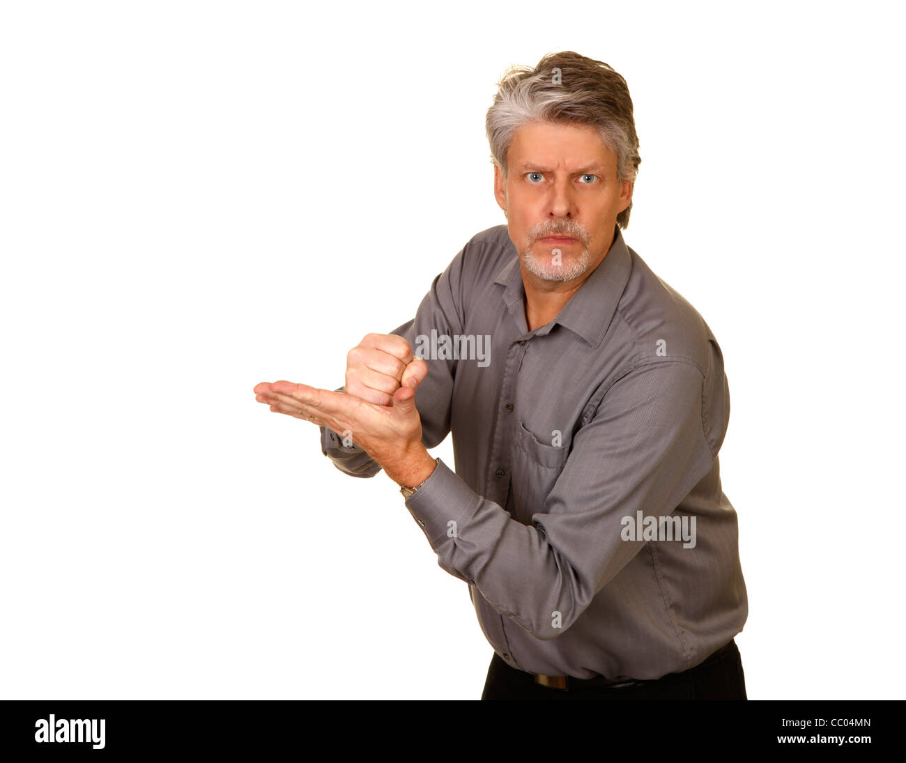 Angry man hitting his palm with his fist Stock Photo