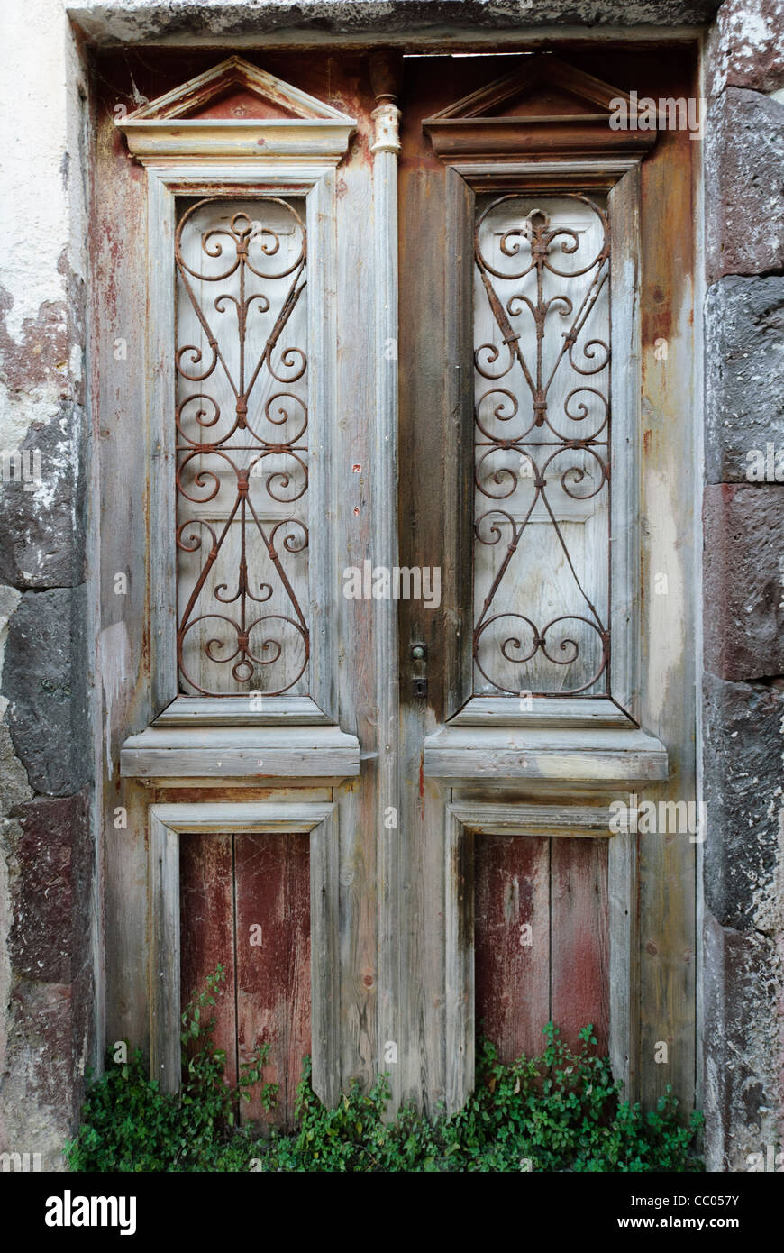 A pair of dilapidated old wooden panelled doors in Oia, Santorini, Greece Stock Photo