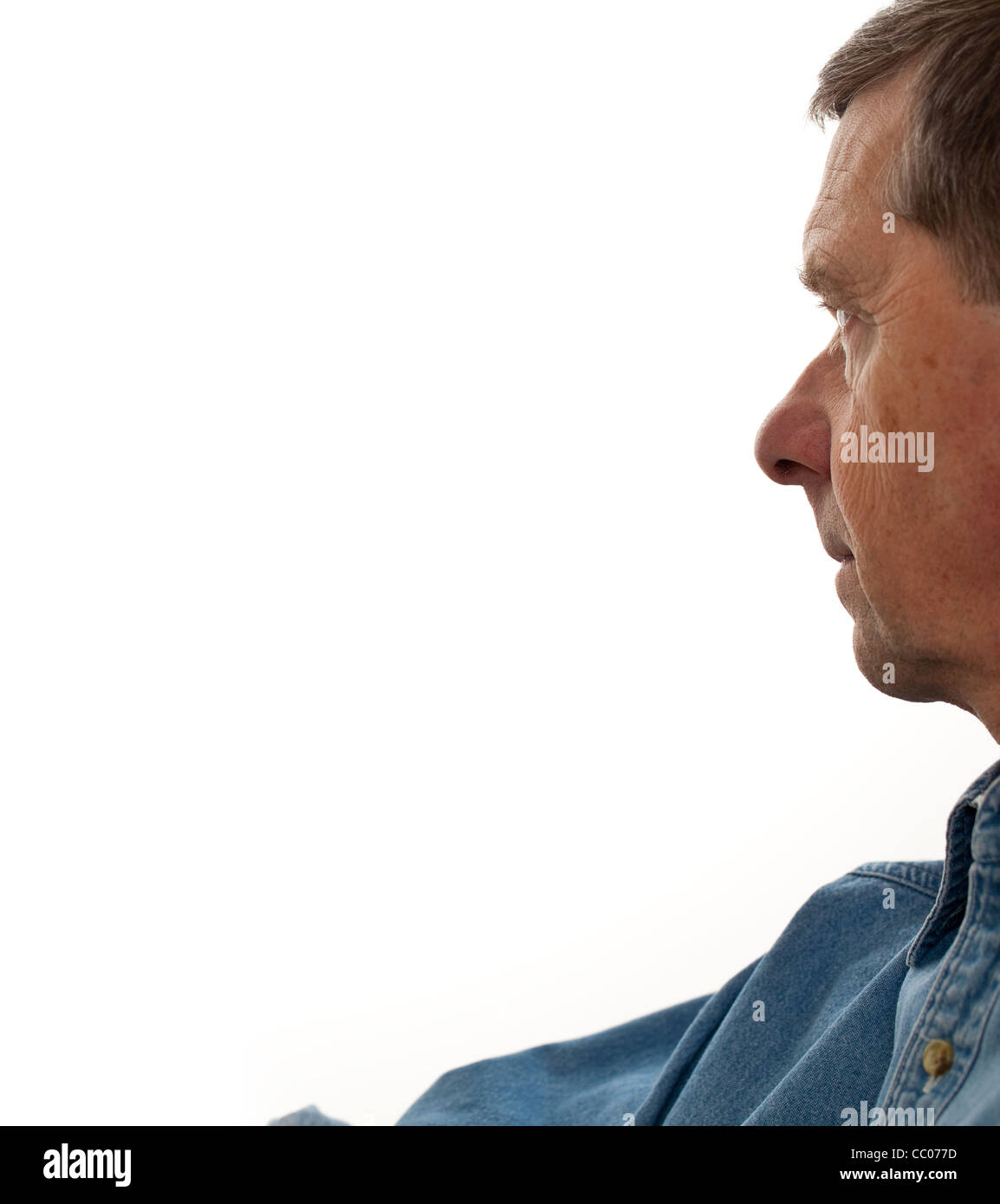 Profile of a middle aged man reaching for something to the left of the page and staring into the distance Stock Photo
