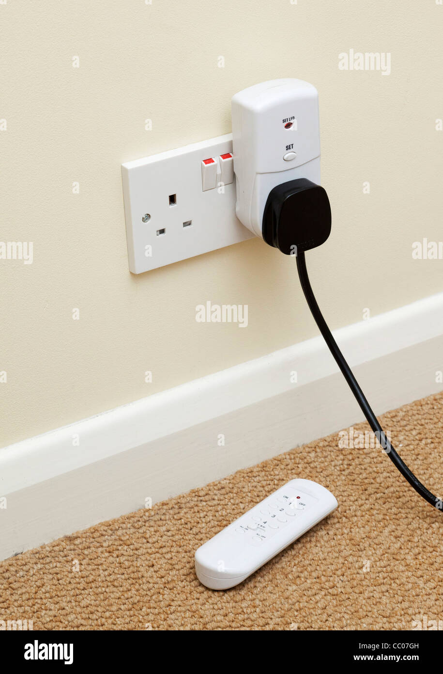 remote controller for controlling electrical appliance plugged into mains wall socket Stock Photo