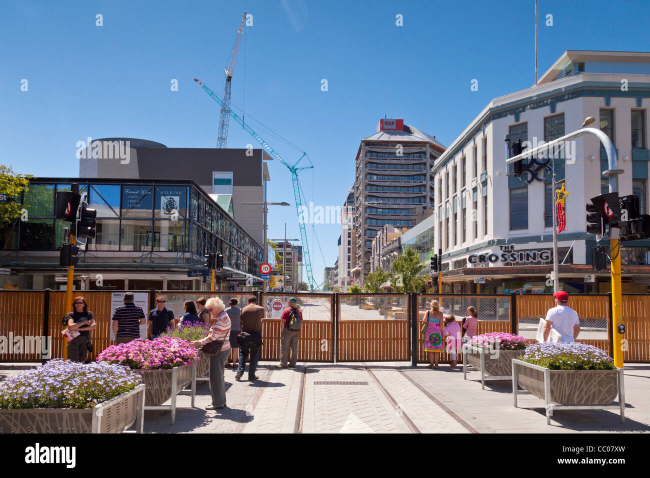 People looking through the fence into the Red Zone, the earthquake  damaged area of central Christchurch, New Zealand. Stock Photo