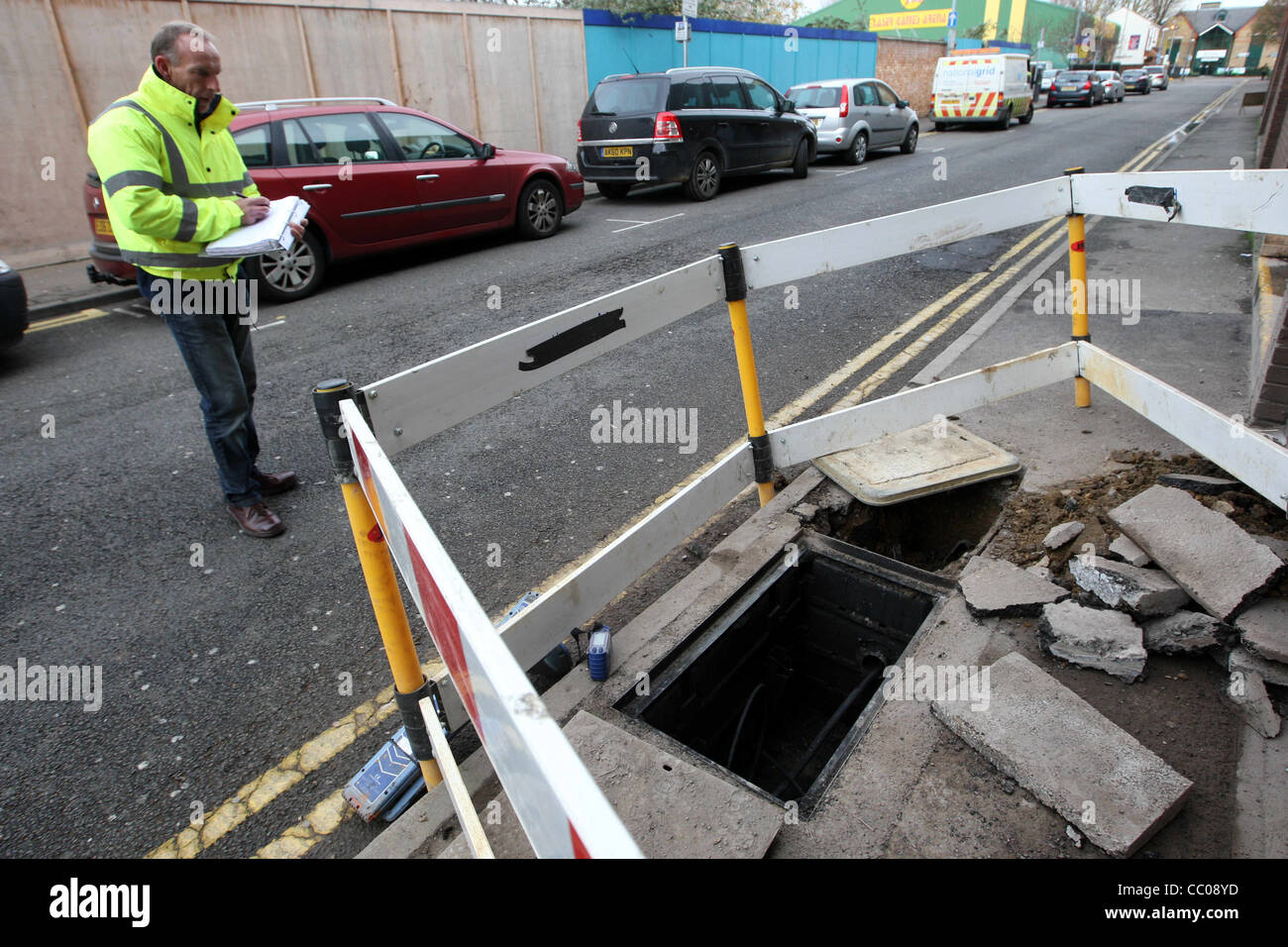 WORKMEN CHECKING A BURST GAS PIPE UNDER A PAVEMENT IN PETERBOROUGH