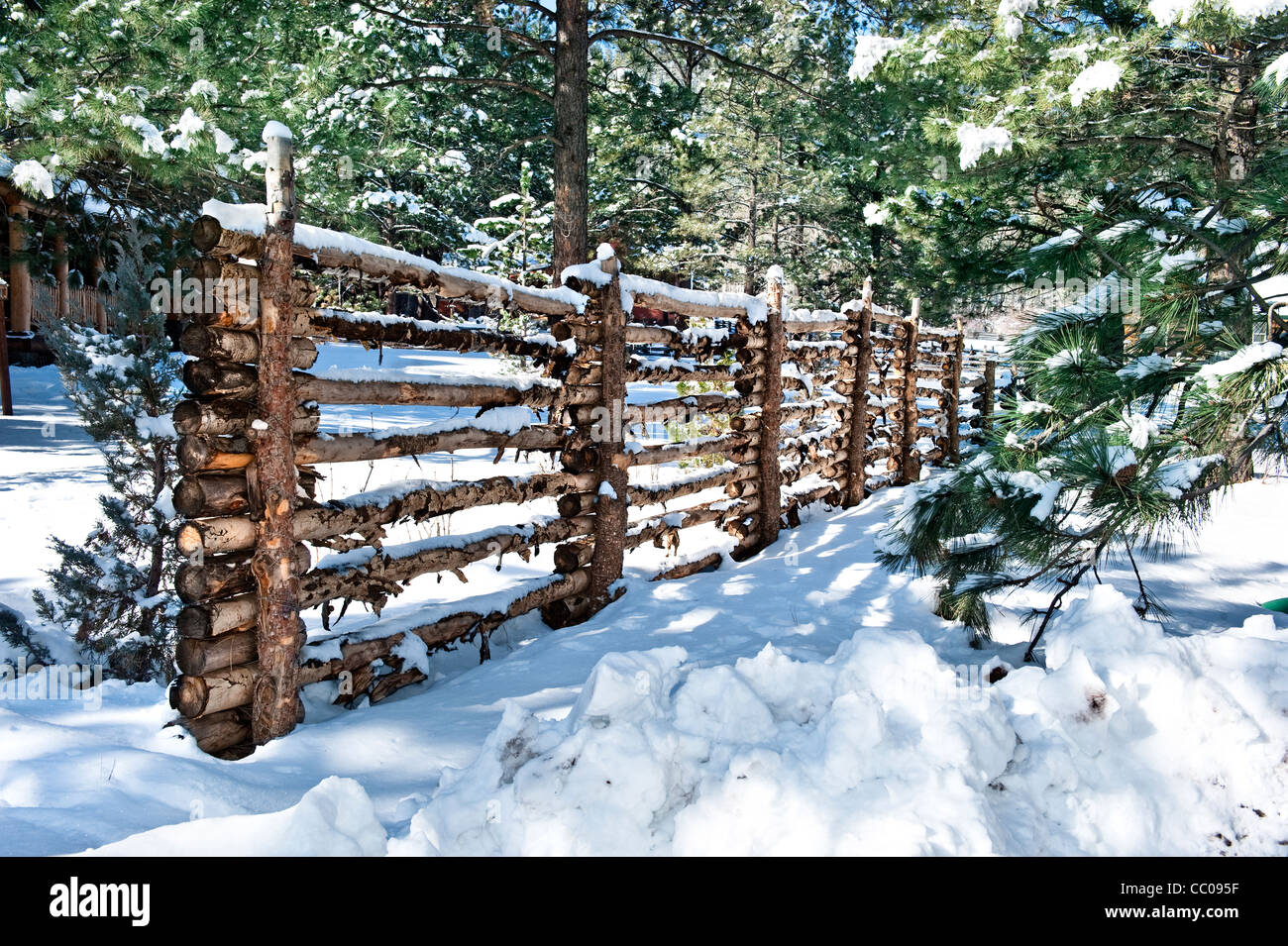 A traditional log fence defines the boundaries of private property. Stock Photo