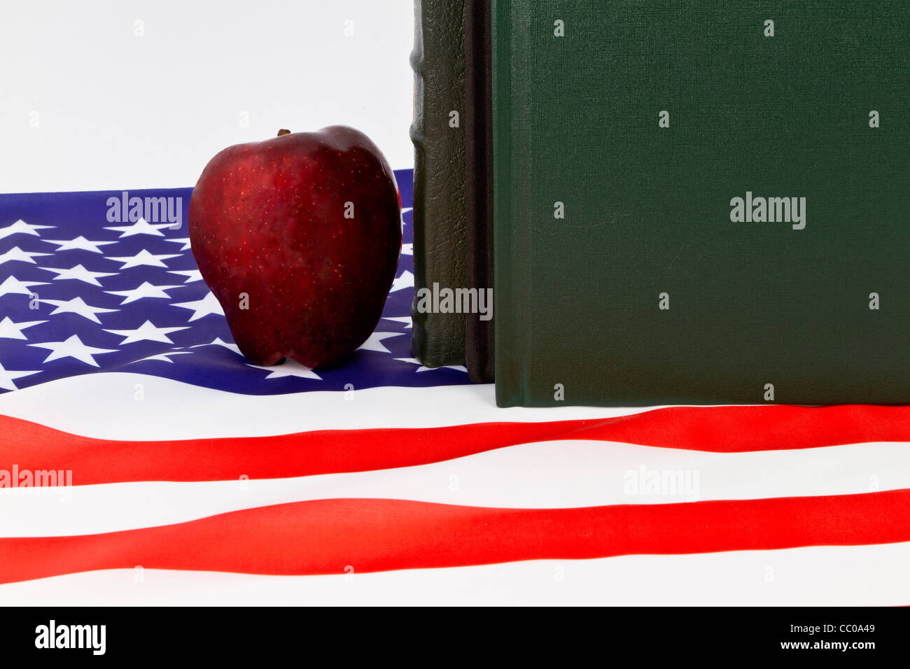 A red apple and books; symbols of teachers and schools; is placed on an