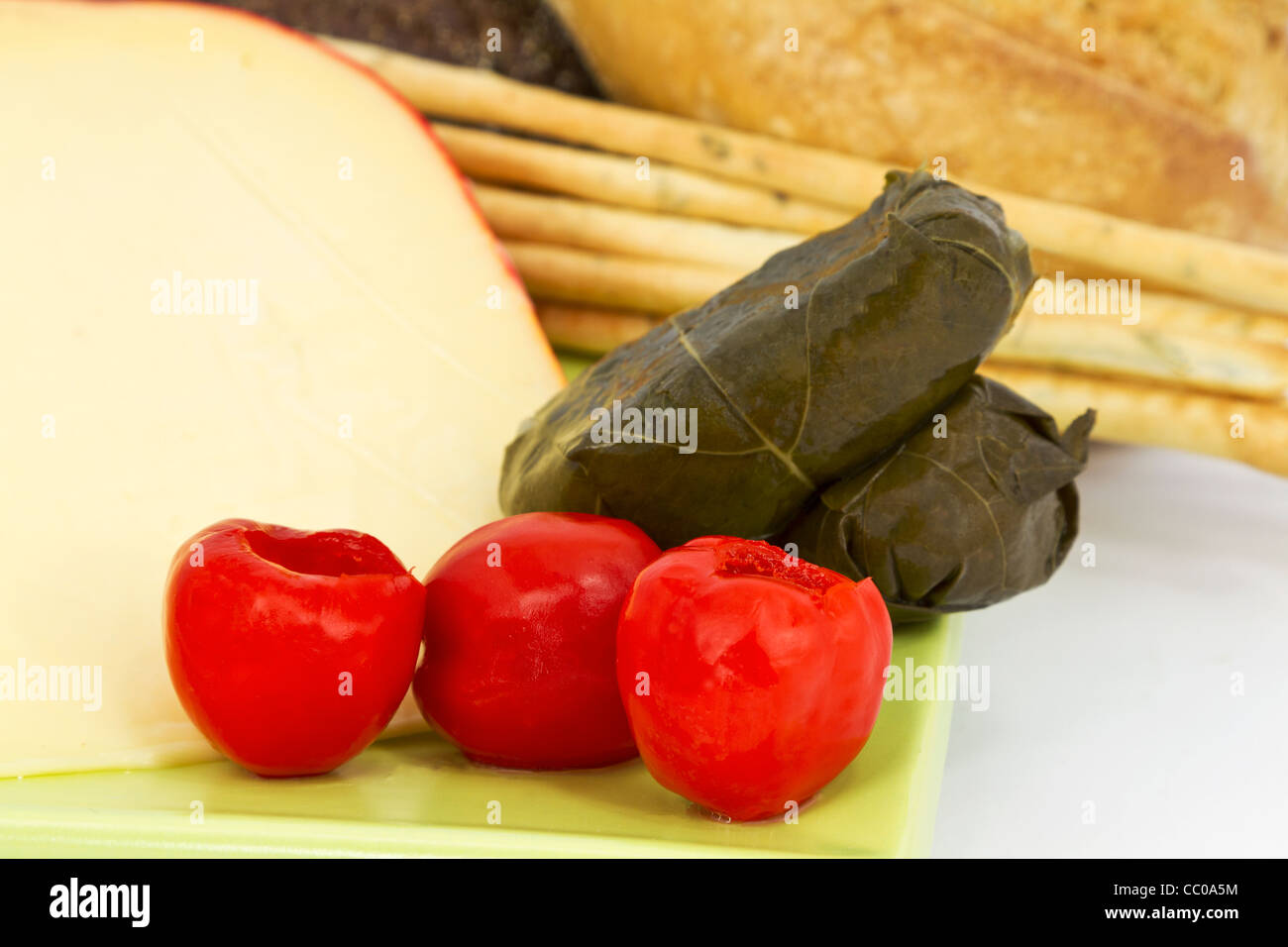 Red rind cheese placed with red peppadews and stuffed grape leaves with