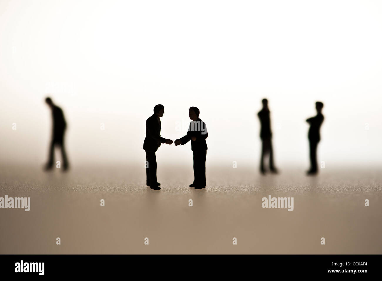 silhouetted small figures conceptual image for business men meeting talking conversation Stock Photo