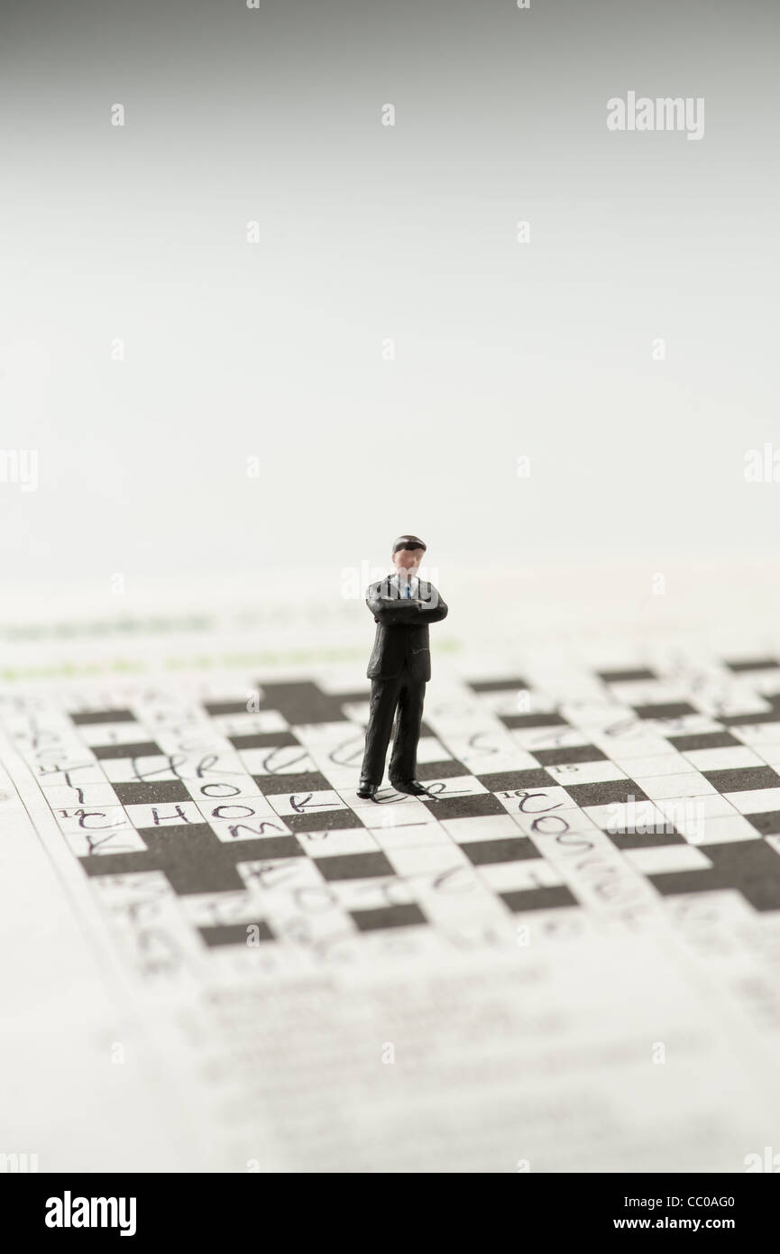 a small figure of a man on a crossword puzzle Stock Photo