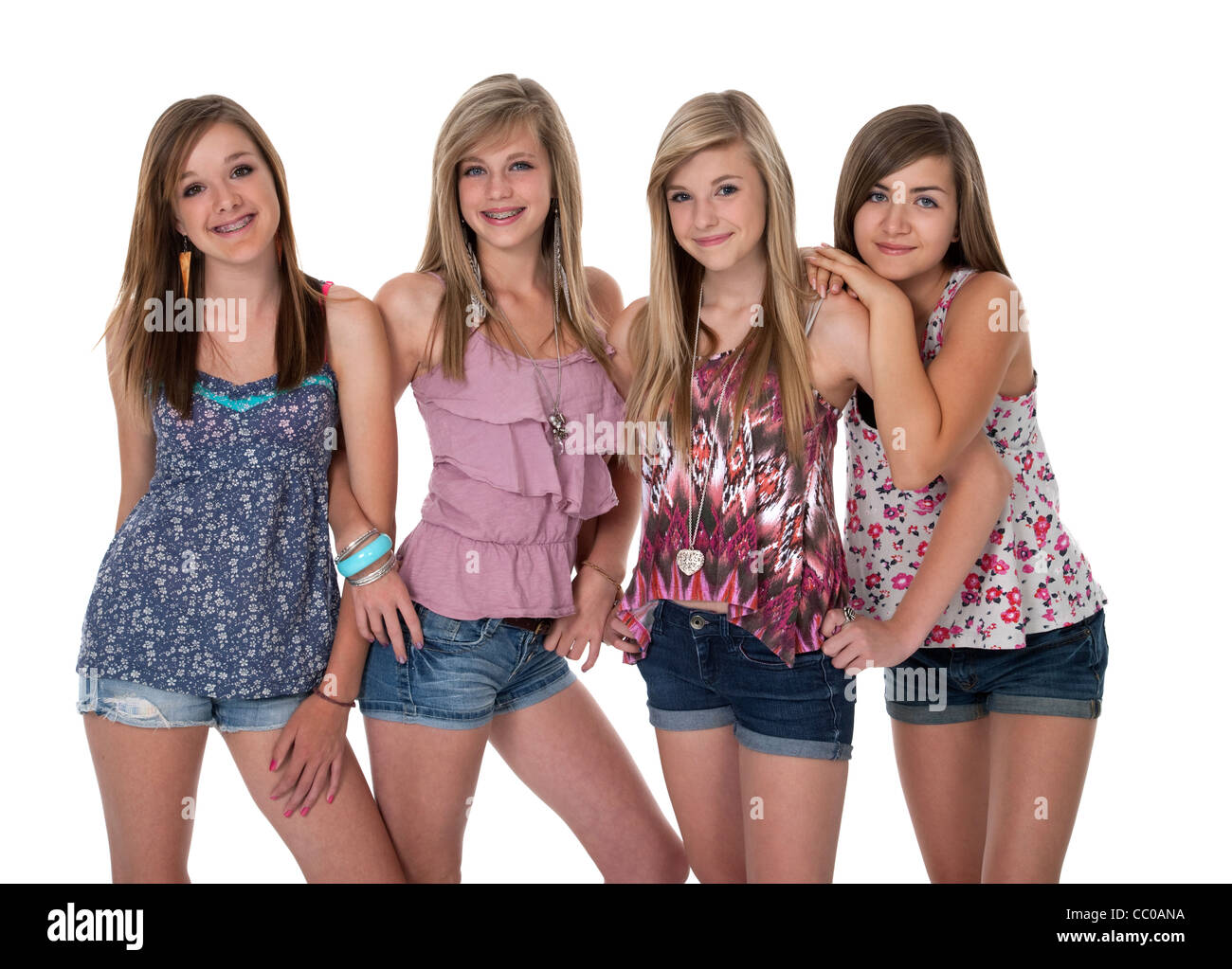 Studio photo of four pretty teenage girls in tight group on white
