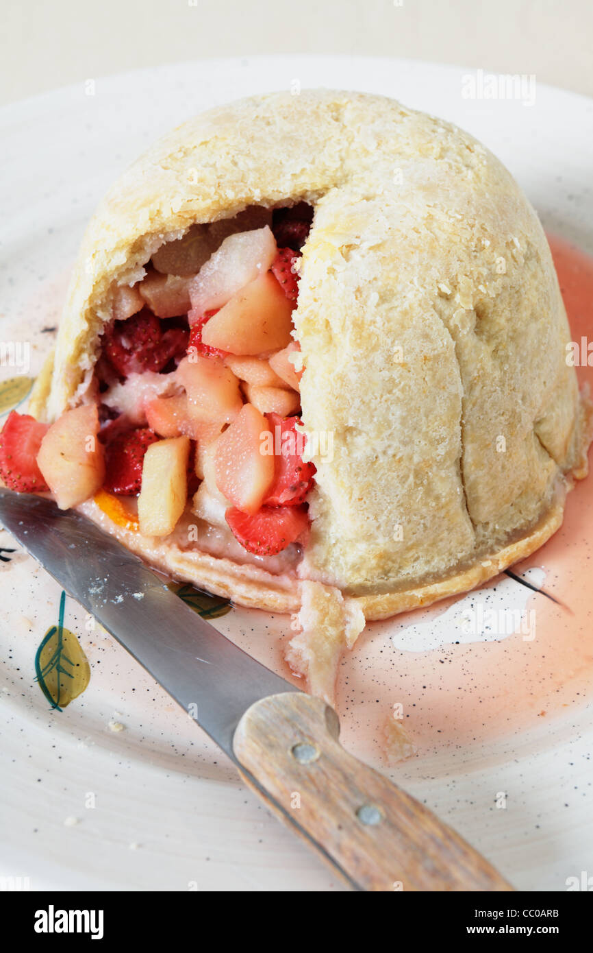 Traditional british steamed strawberry and pear fruit pudding on a dish