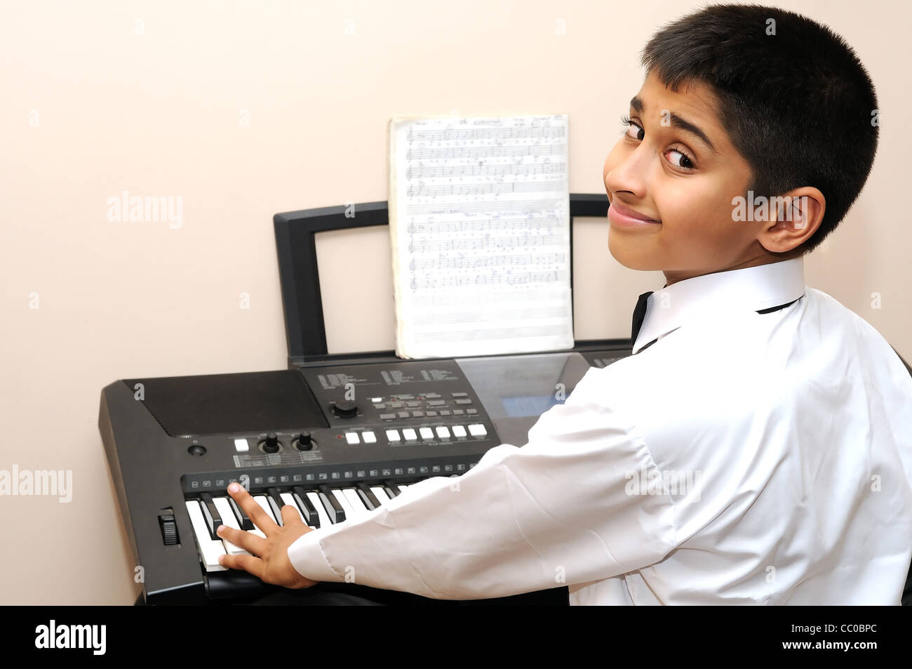 An handsome Indian boy learning music with an electric piano Stock ...