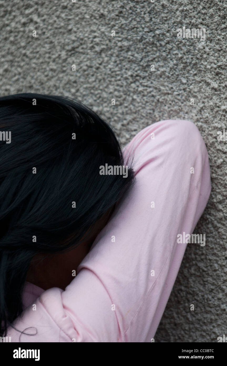 Woman crying against the wall Stock Photo
