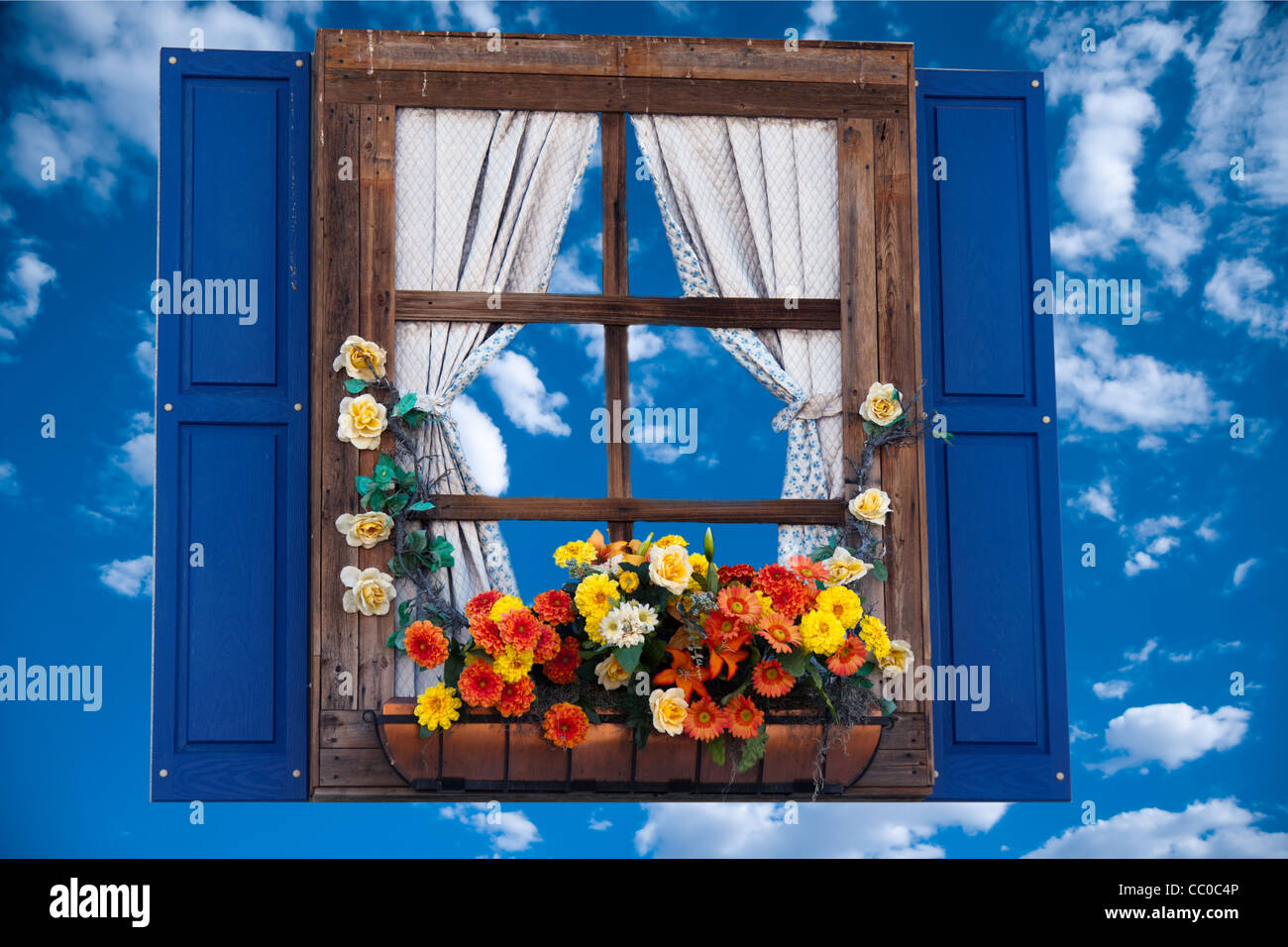 Country style window with flowers,planter, shutters and curtains,sky Stock Photo