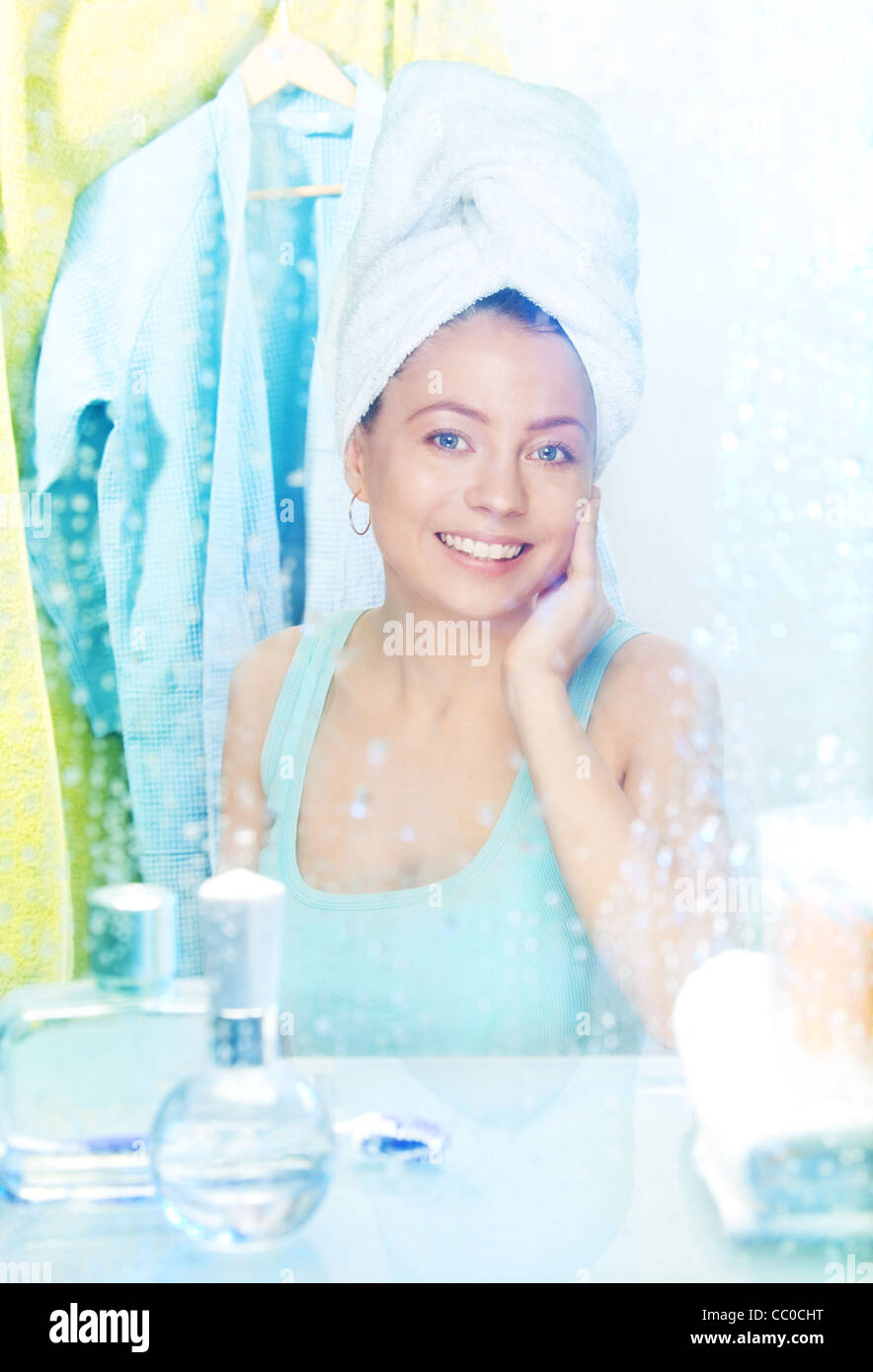 Camera behind the mirror - woman having a shower and smiling Stock Photo