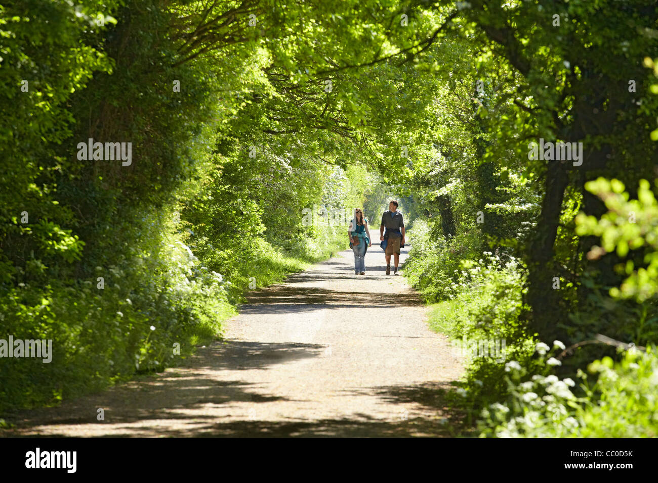 A couple walking along the Wirral Way footpath, Wirral, UK on a warm late spring afternoon Stock Photo