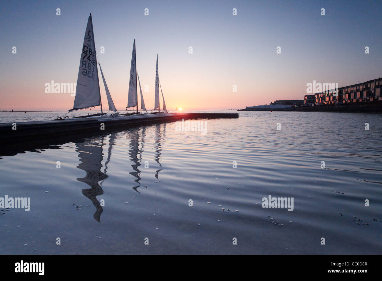 Three sailing boats moored at sunset on the marine lake at West Kirby, Wirral, UK Stock Photo