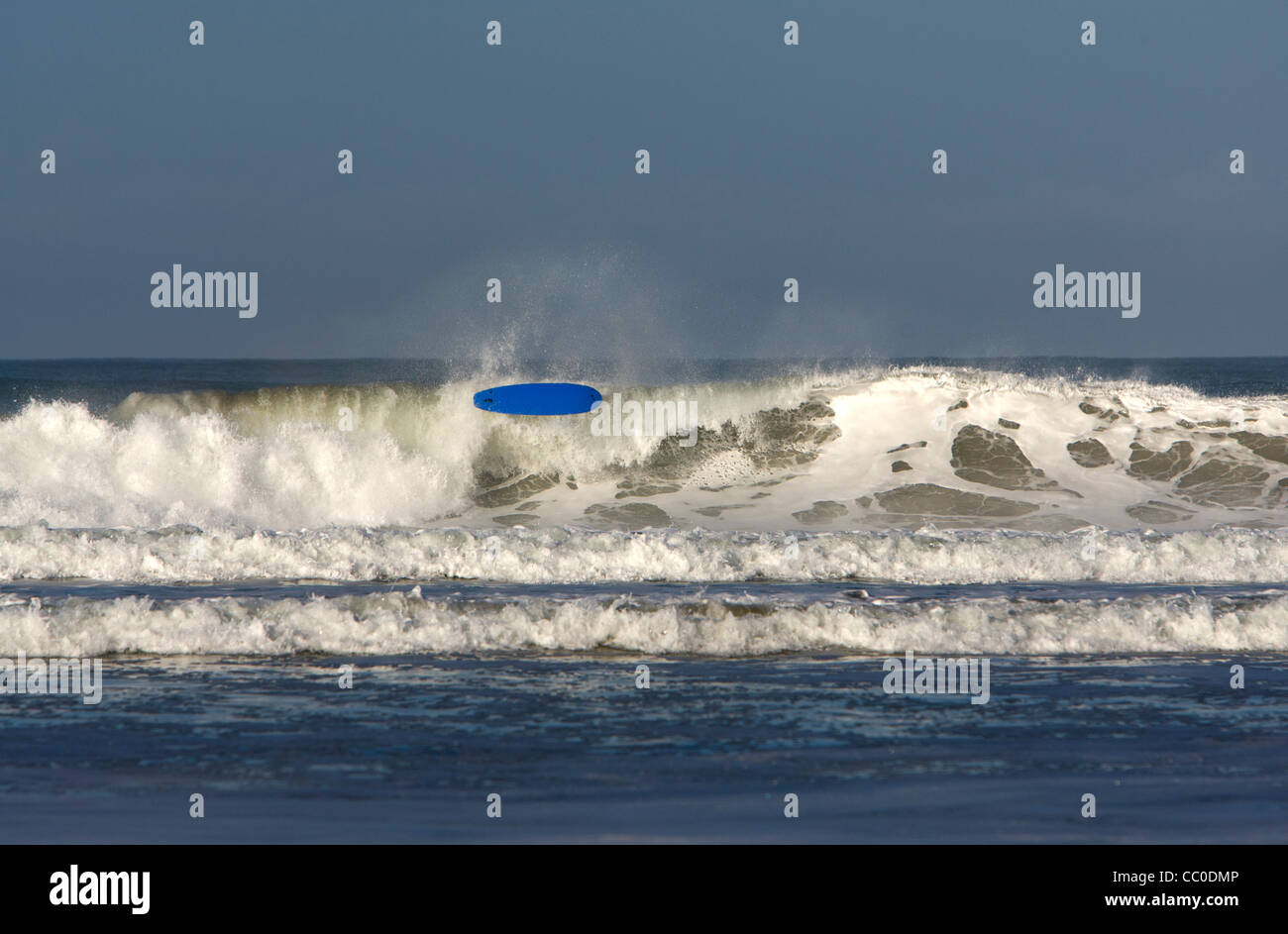 A surfer wipes out on a big wave at Porthtowan beach, Cornwall. Stock Photo