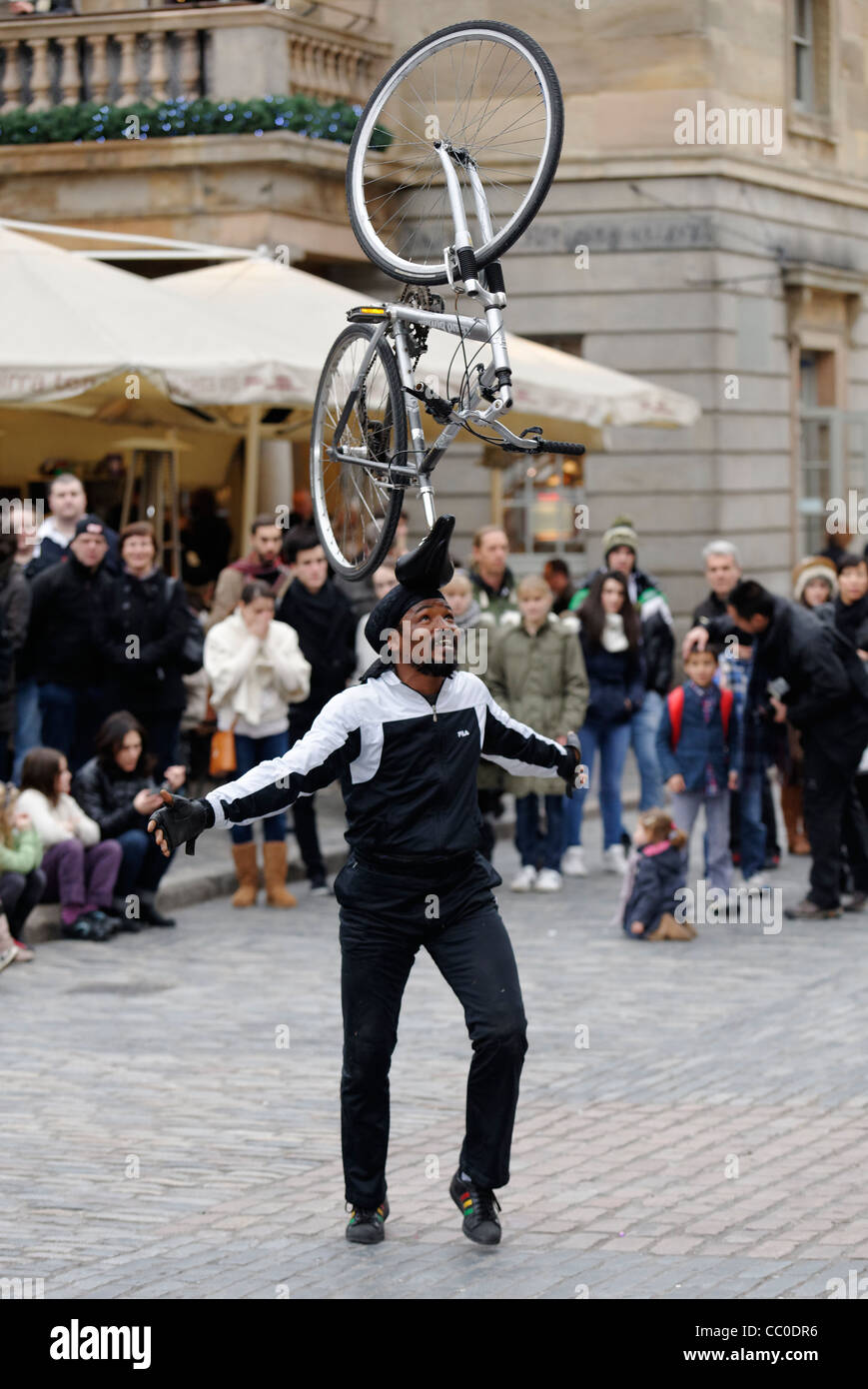 Street entertainer balancing a bicycle on his head in the Piazza at Covent Garden, London Stock