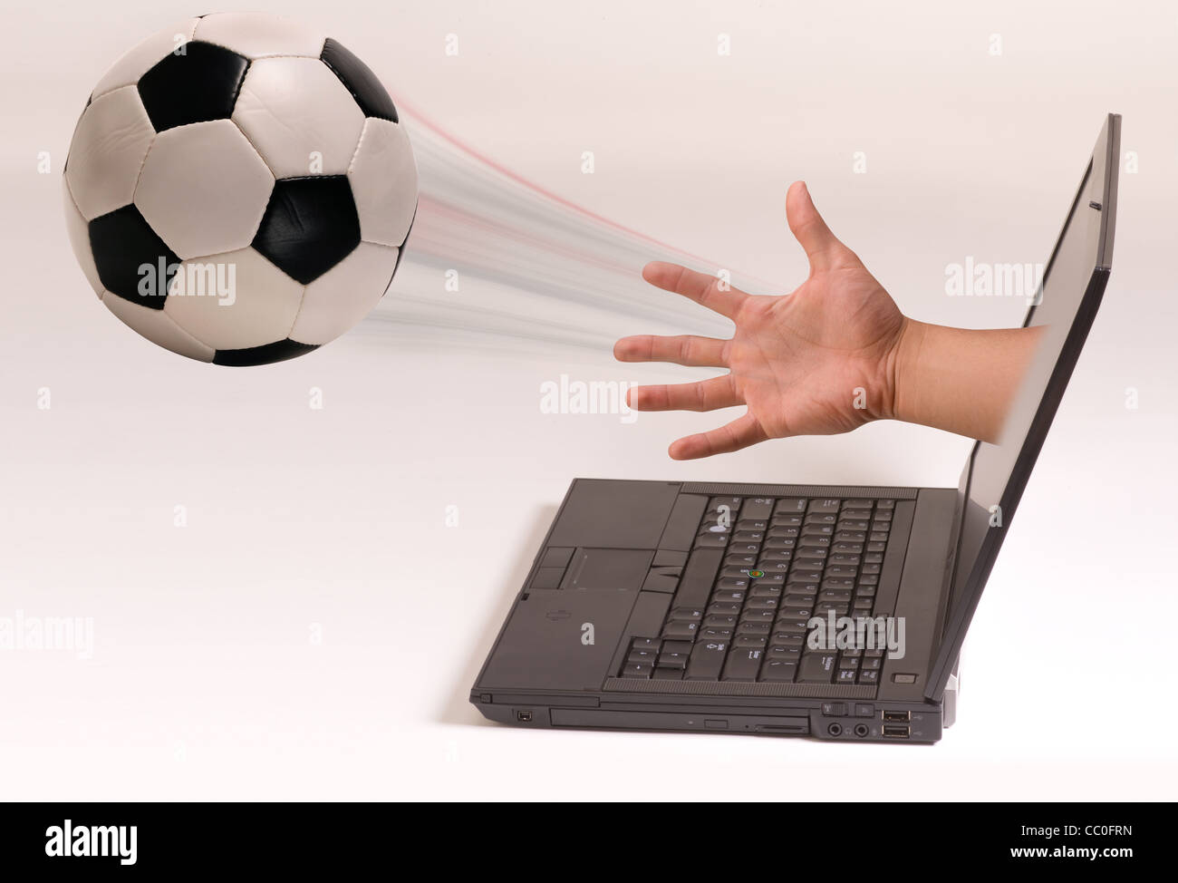 Soccer ball out of laptop screen Stock Photo Alamy