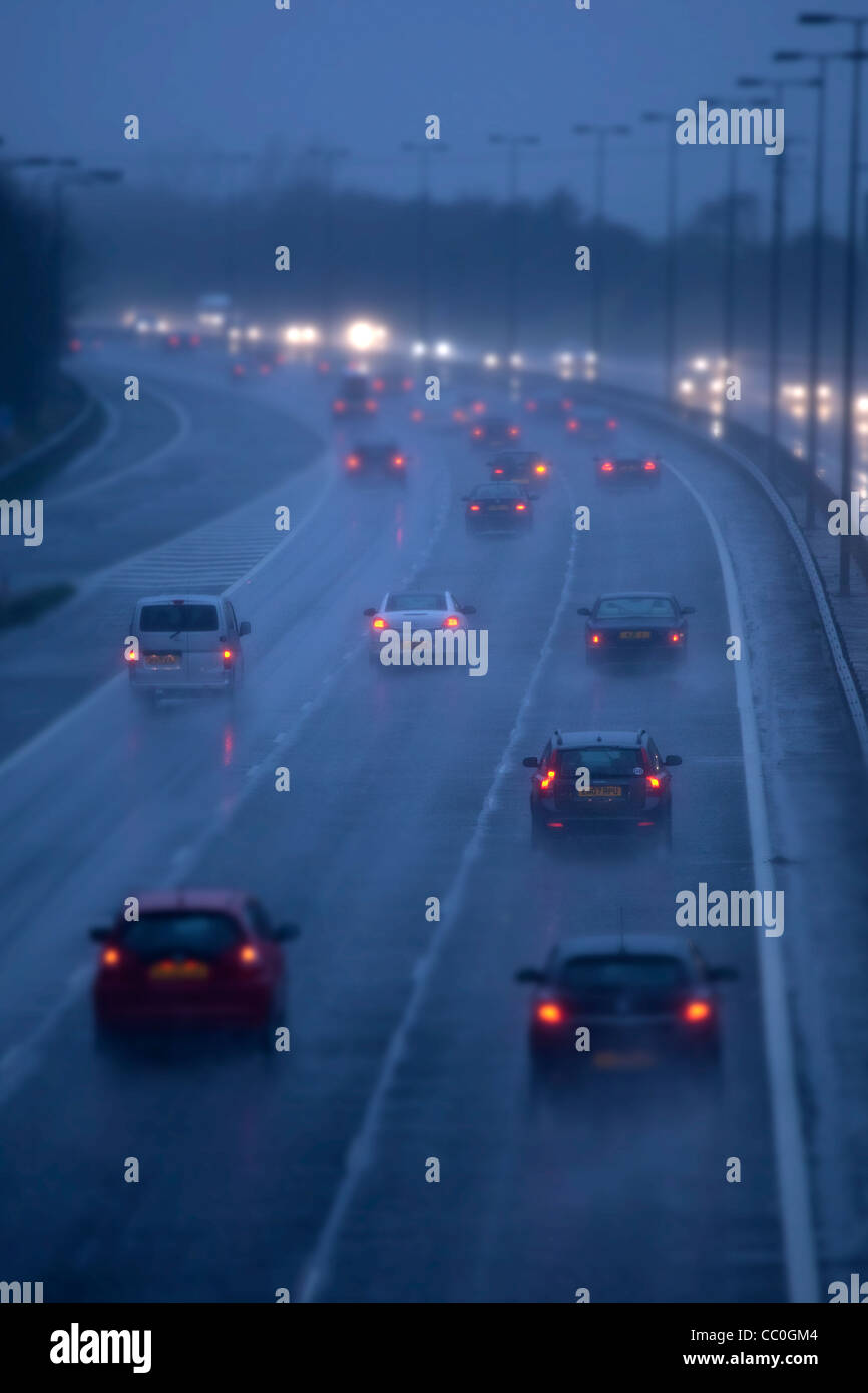 Cars and traffic on a wet raining evening on uk motorway.Driving in dangerous winter conditions. Stock Photo